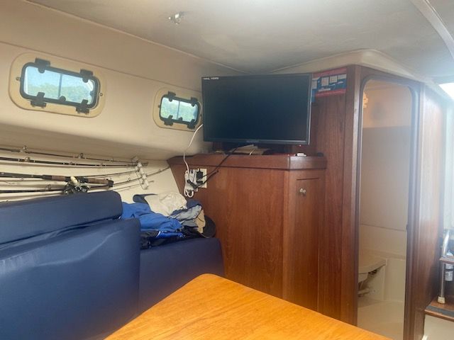 Interior of 1999 Mainship Pilot 30 with TV, seating, and storage.
