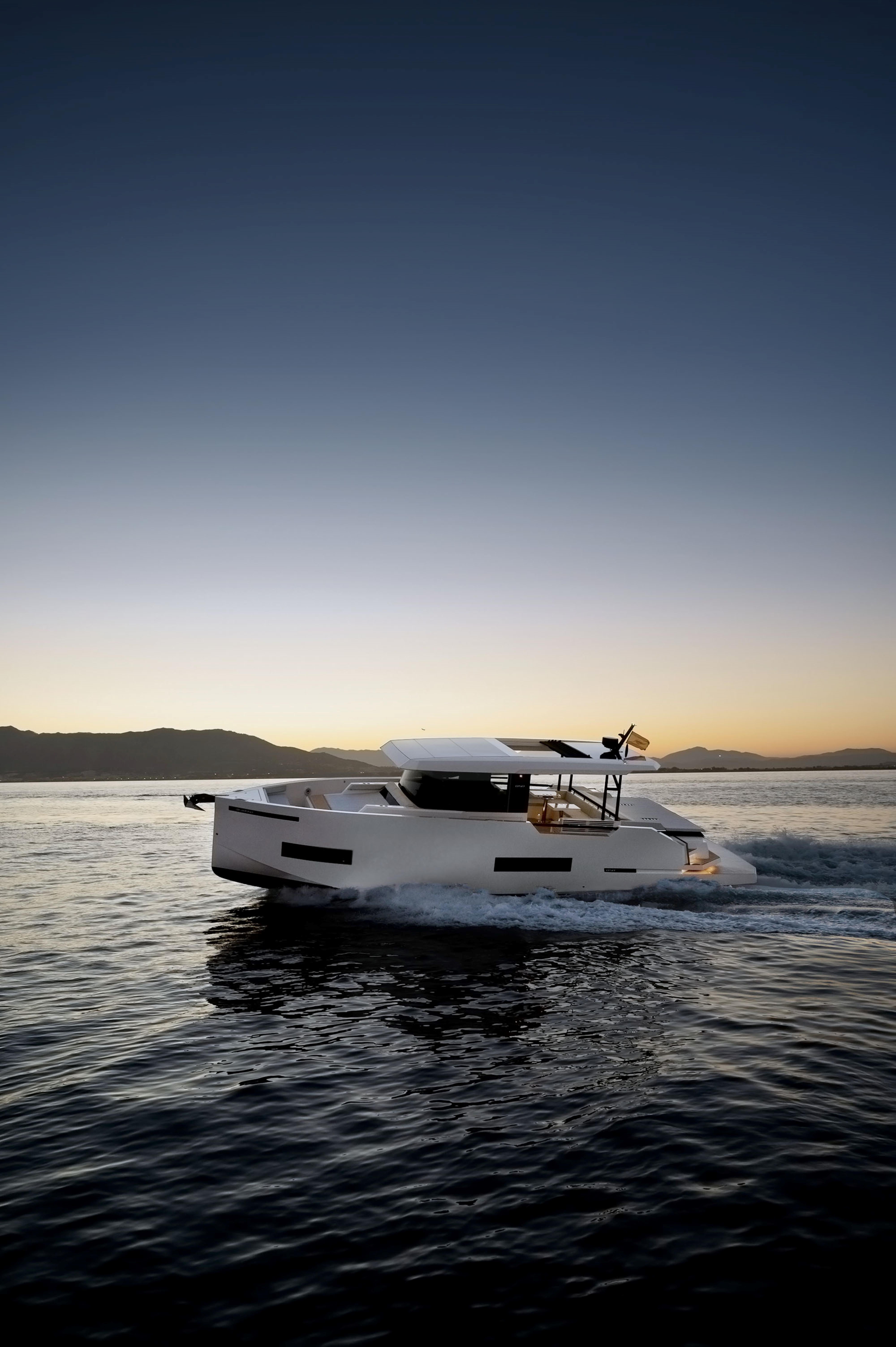 2024 De Antonio Yachts D50 Coupé cruising at sunset on calm waters.