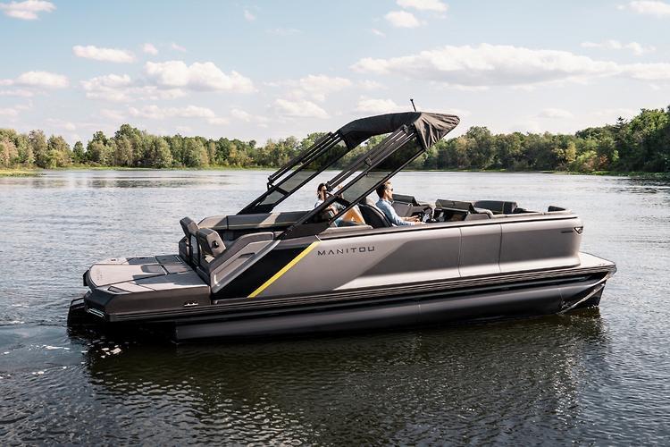 2025 Manitou EXPLORE 22 MAX SWITCHBACK pontoon boat cruising on a serene lake.