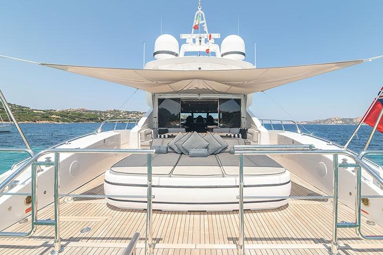 Luxurious 2010 Mangusta 92 yacht with spacious deck and sunshade on open water.
