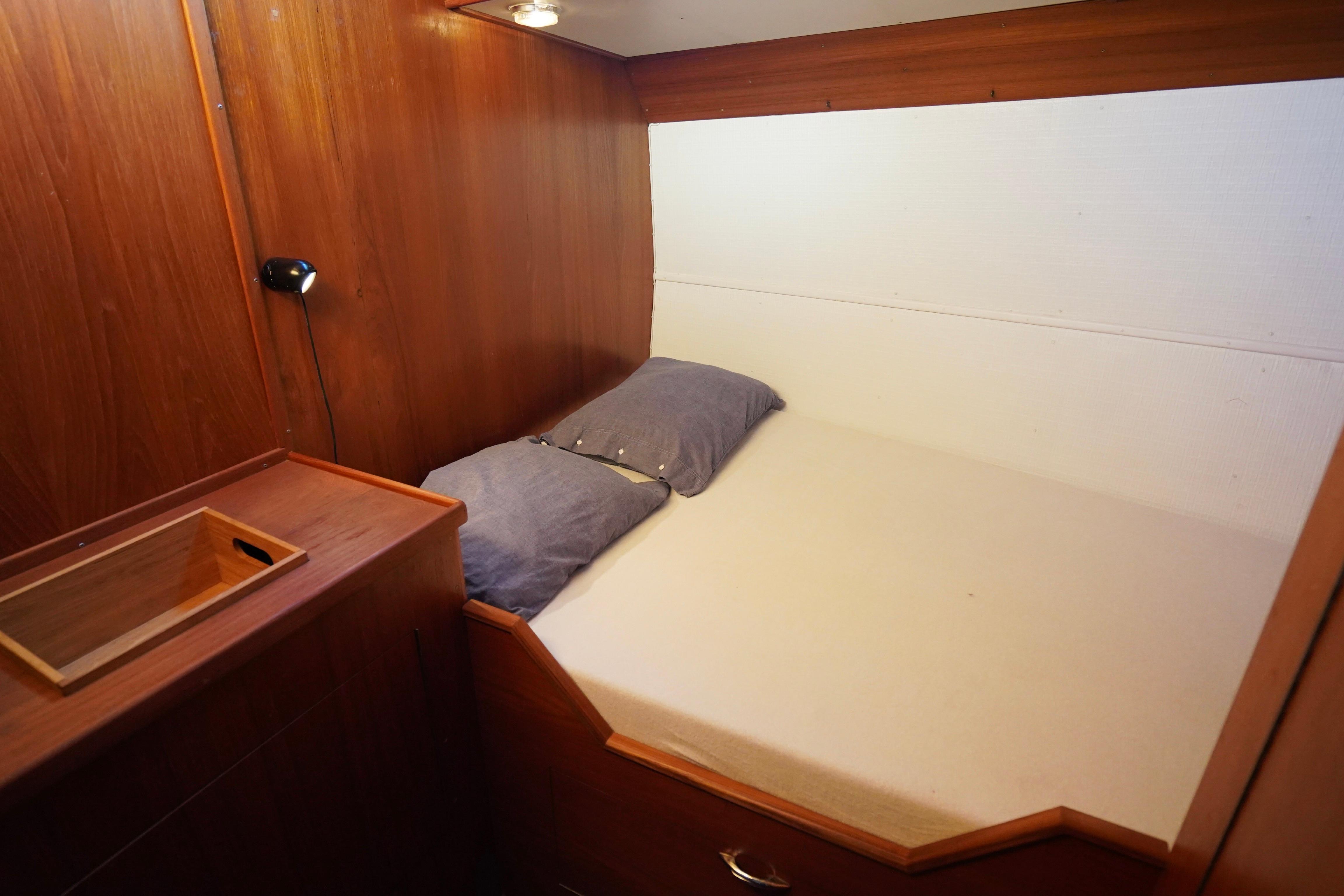 Cozy cabin interior of 1977 De Vries Lentsch 57 Classic Ketch with wooden paneling.