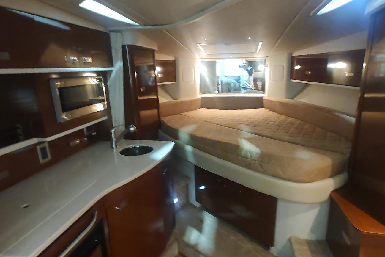 Interior of 2011 Sea Ray 330 Sundancer yacht with kitchenette and cozy sleeping area.
