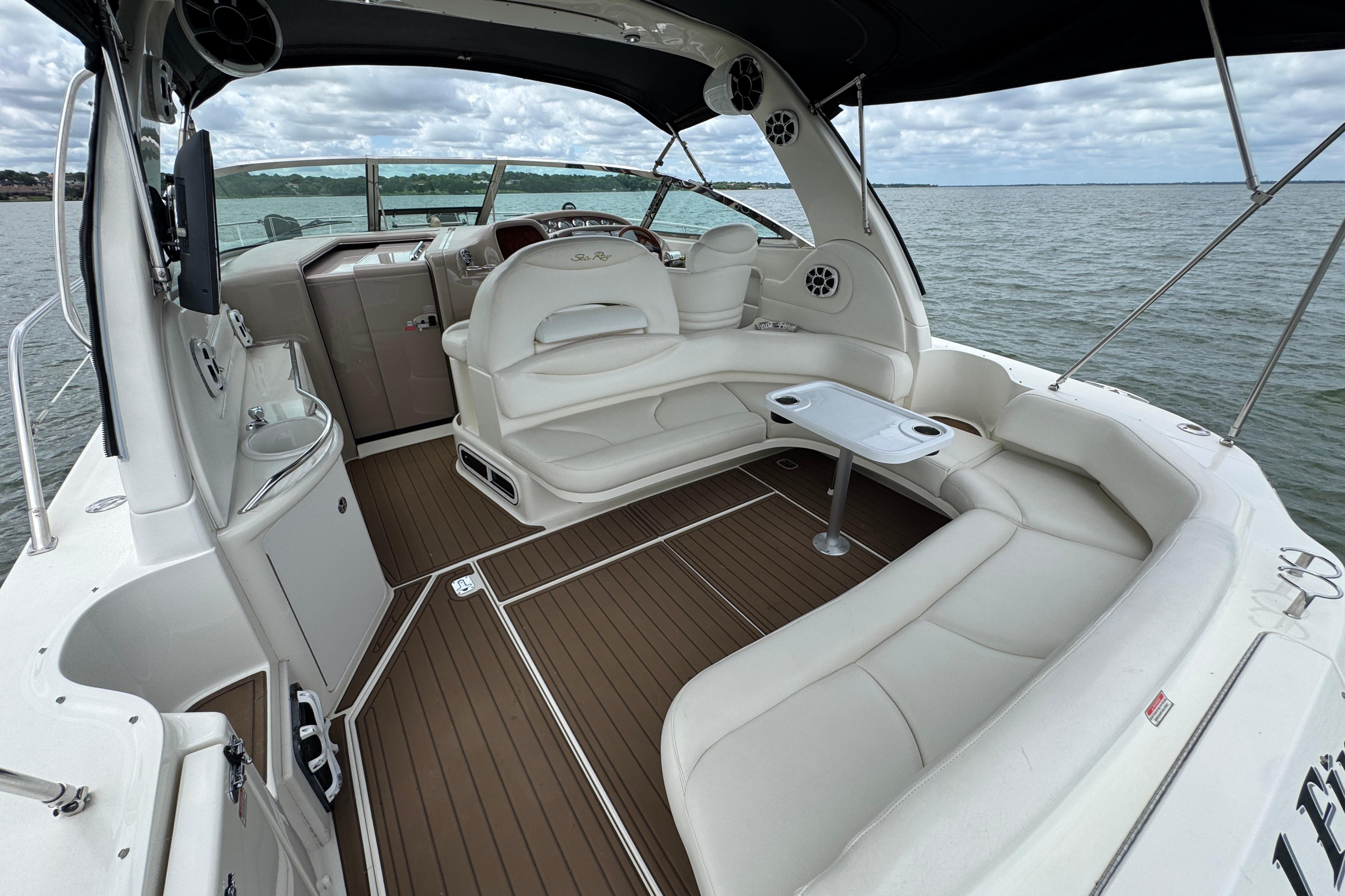 2001 Sea Ray 380 Sundancer boat interior with white seating and wood flooring on the water.