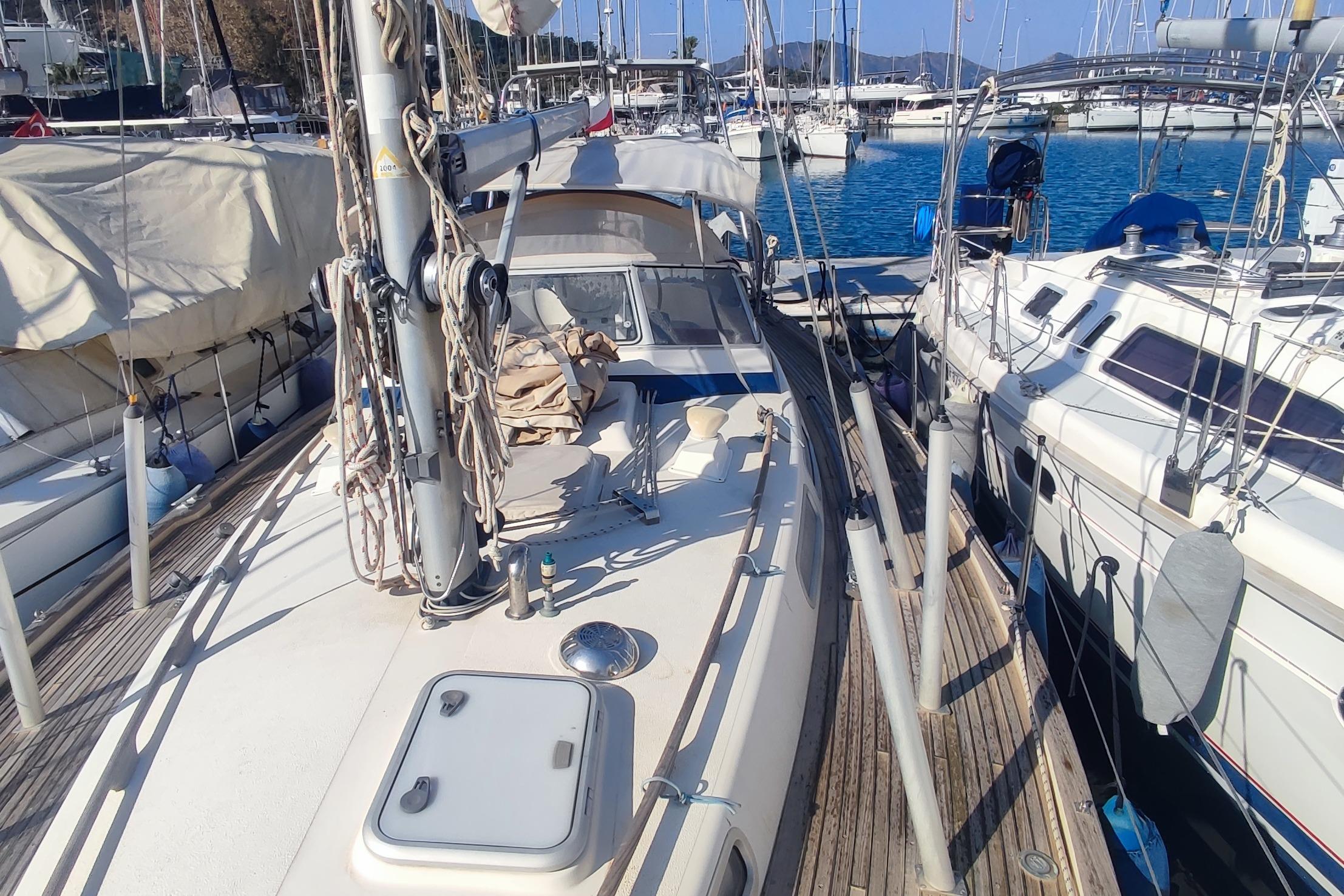2002 Hallberg-Rassy 36 MKII sailboat docked in a marina, surrounded by other boats.