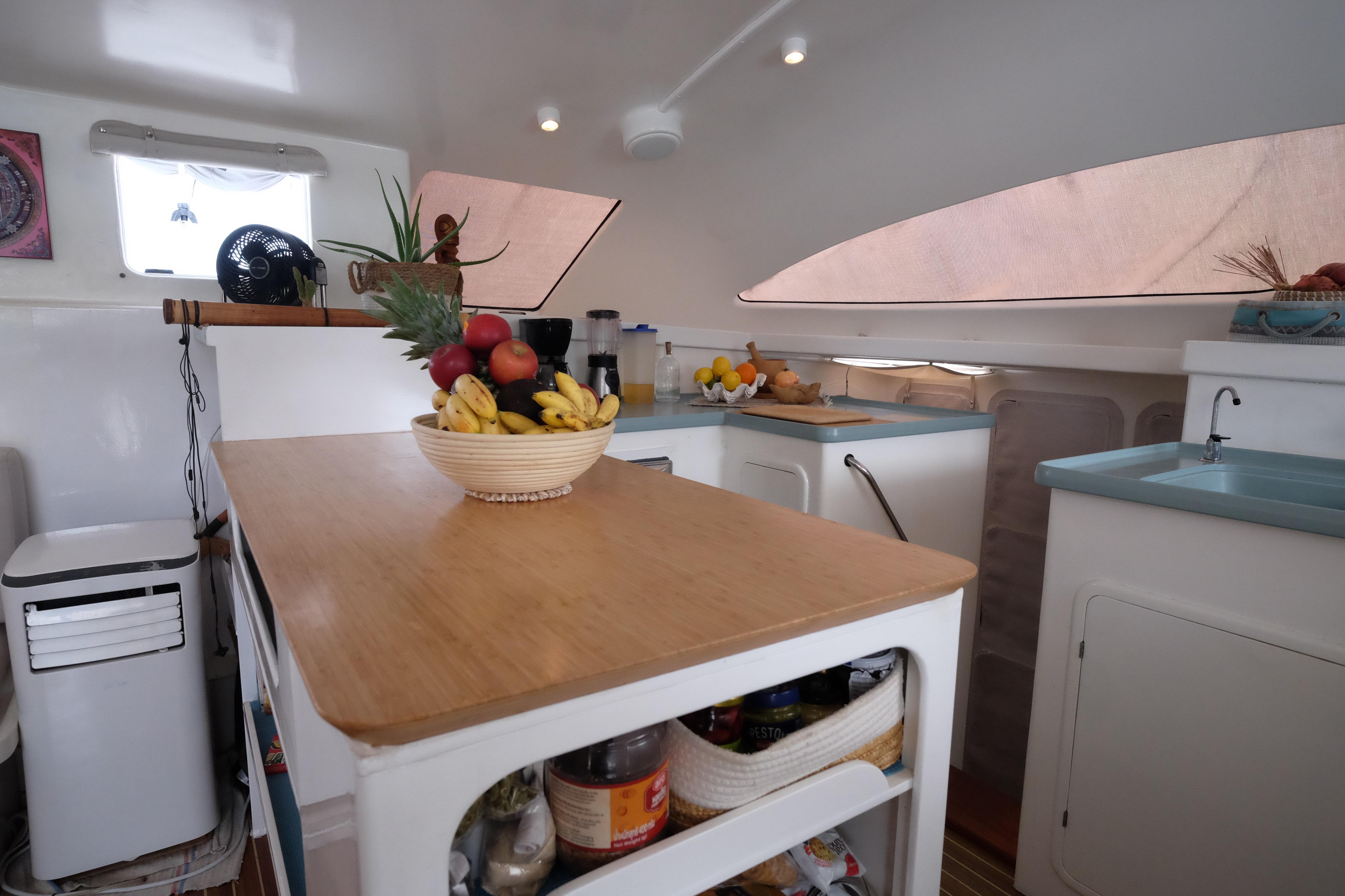 Modern boat kitchen interior with fruit bowl, wooden countertop, and sleek design. Punch 1500, 2003 model.