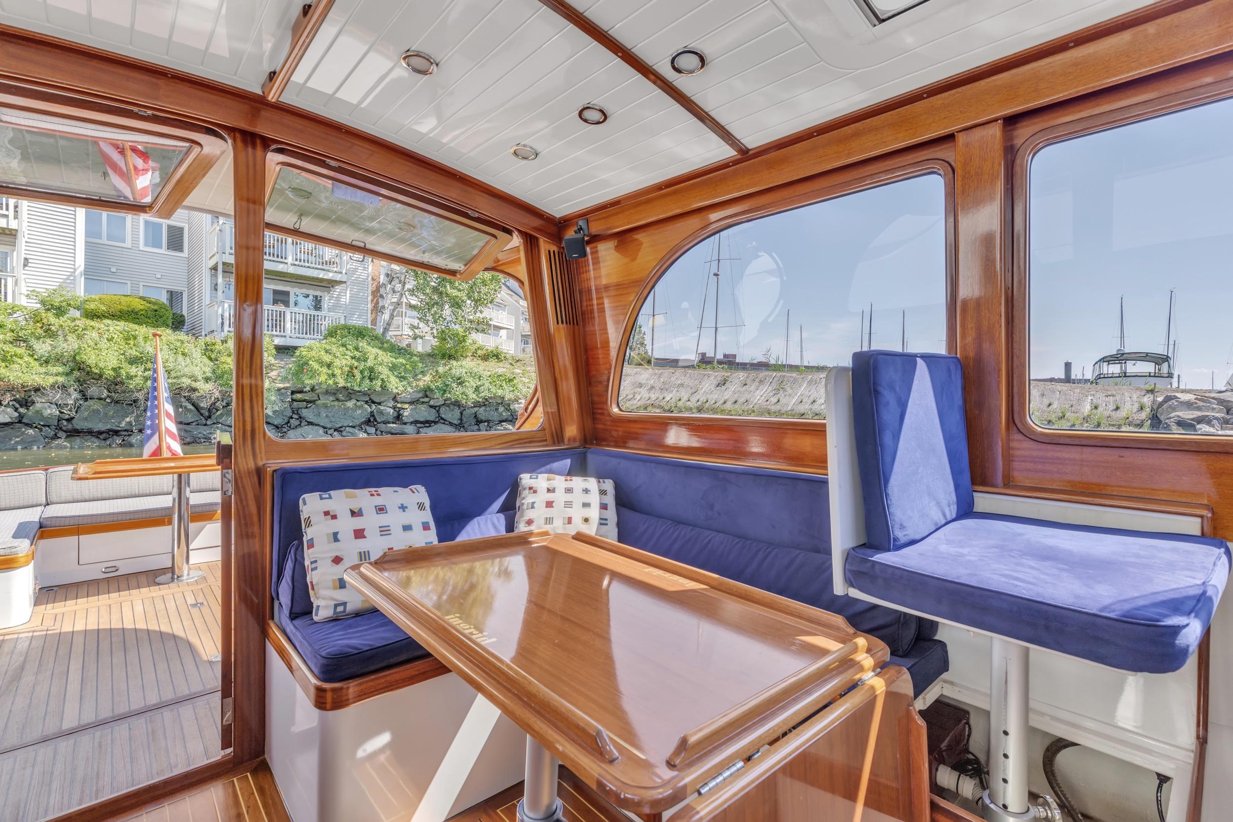 Luxurious 2007 Gorbon Custom Downeast 40 yacht interior with wooden finish and blue seating.