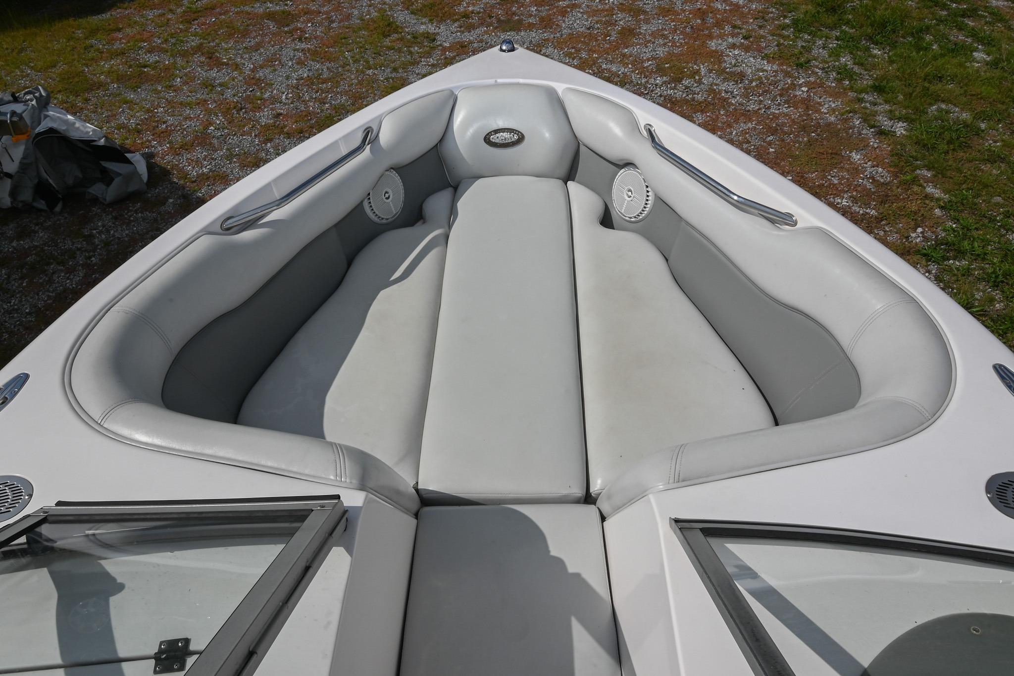 2004 Supra Launch SS boat interior with white cushioned seating and speakers.