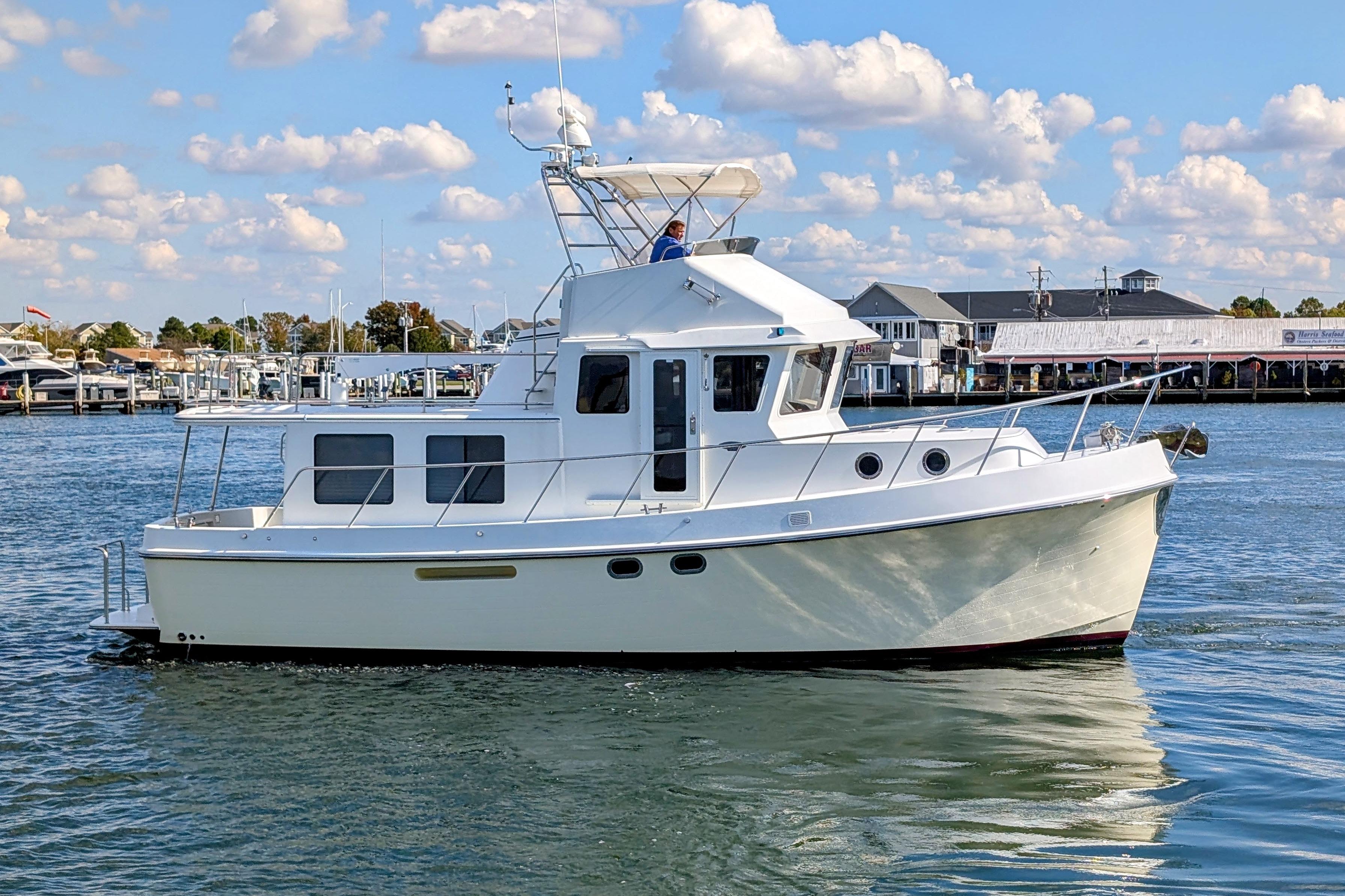2015 American Tug 435 cruising on calm waters under a partly cloudy sky.