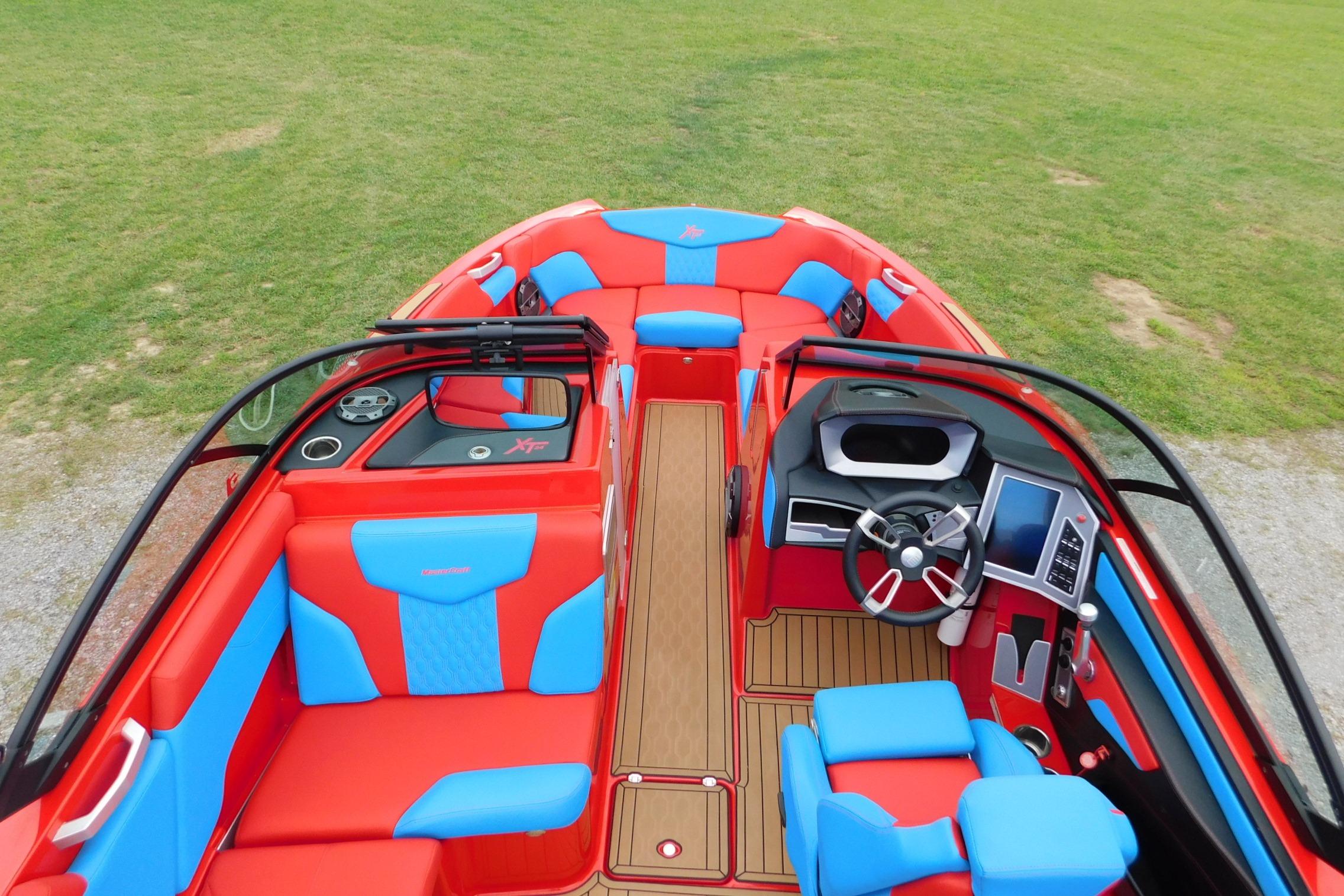 2022 MasterCraft NXT24 boat interior with vibrant red and blue seating, modern dashboard.