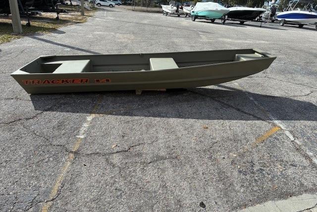 2026 Tracker Grizzly 14 Jon boat on pavement, surrounded by other boats.