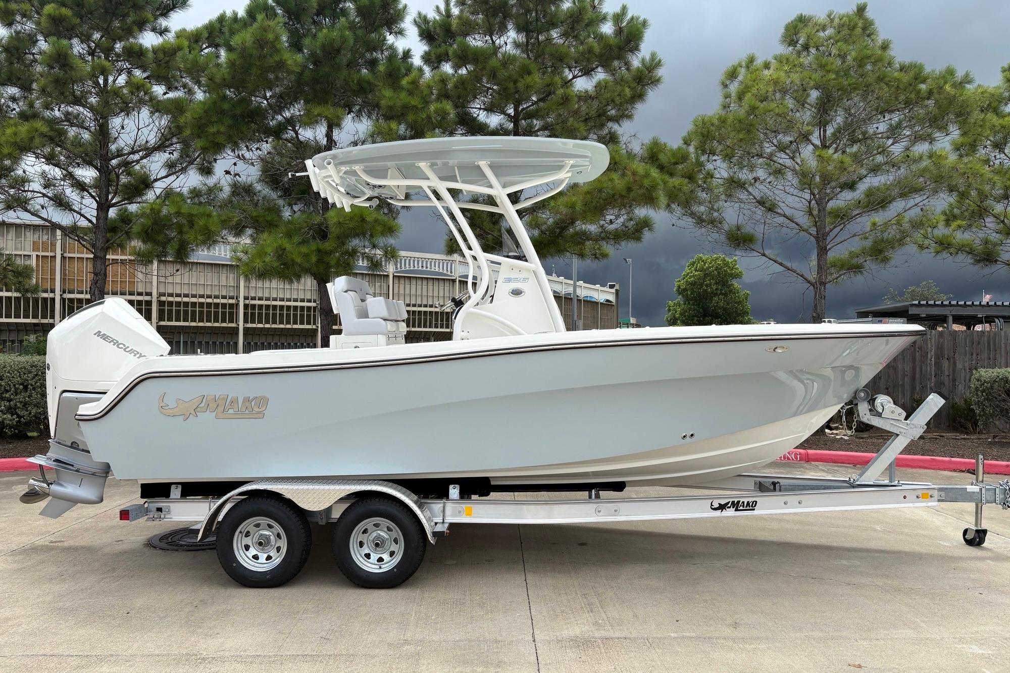 2026 Mako 226 Center Console boat on trailer, parked outdoors with trees in background.
