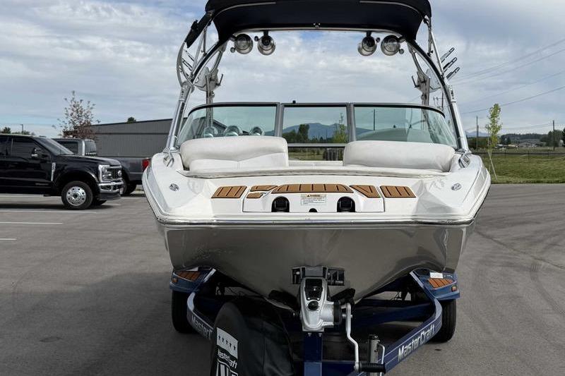 2004 MasterCraft XStar boat on trailer, parked in a lot, front view.