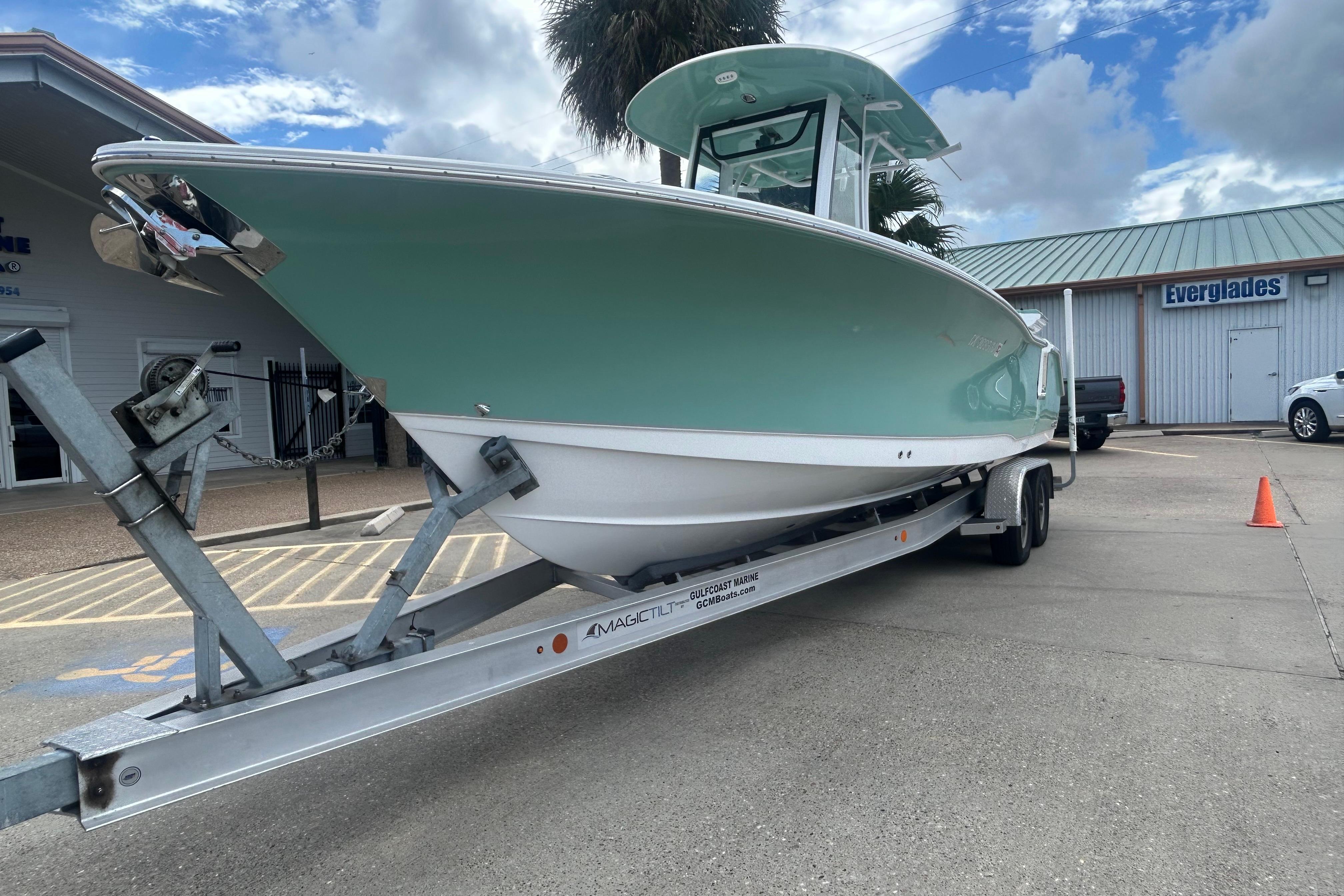 2023 Sea Hunt Gamefish 27 Coffin Box boat on trailer, parked outside a marine shop.