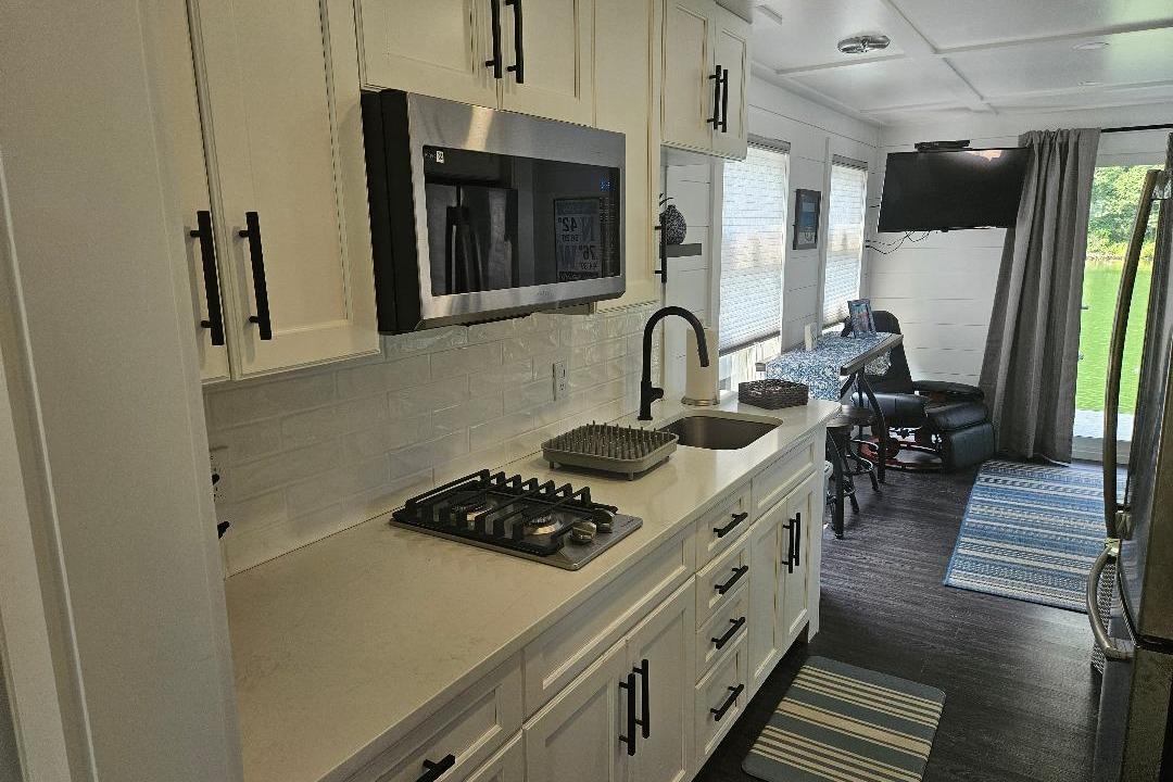 Modern kitchen interior of 2021 East Coast Houseboats Freedom 40, featuring sleek appliances and stylish decor.