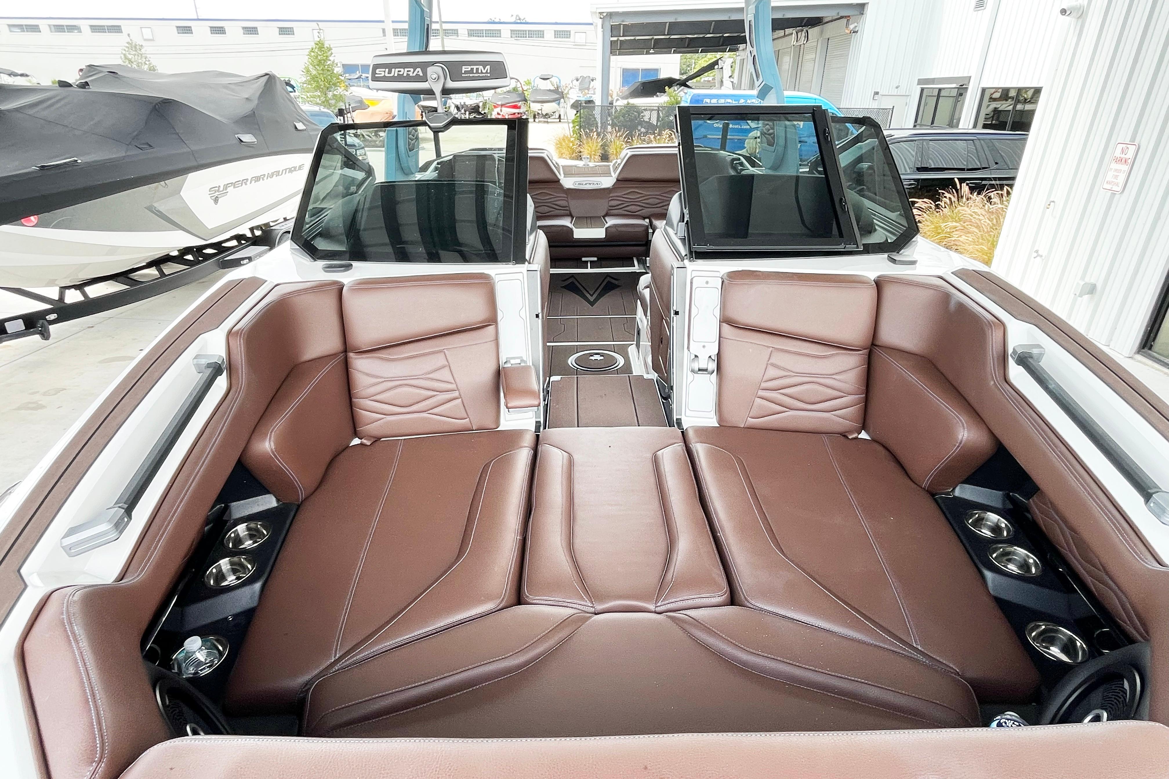 2025 Supra SA450 boat interior with brown leather seating and cup holders.