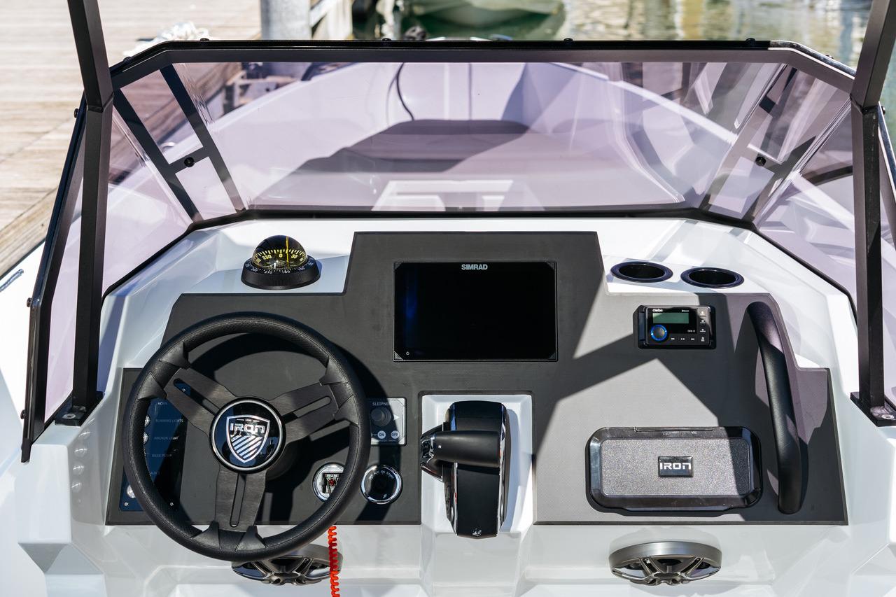 Cockpit of 2024 Custom 827 boat with steering wheel, compass, and navigation display.