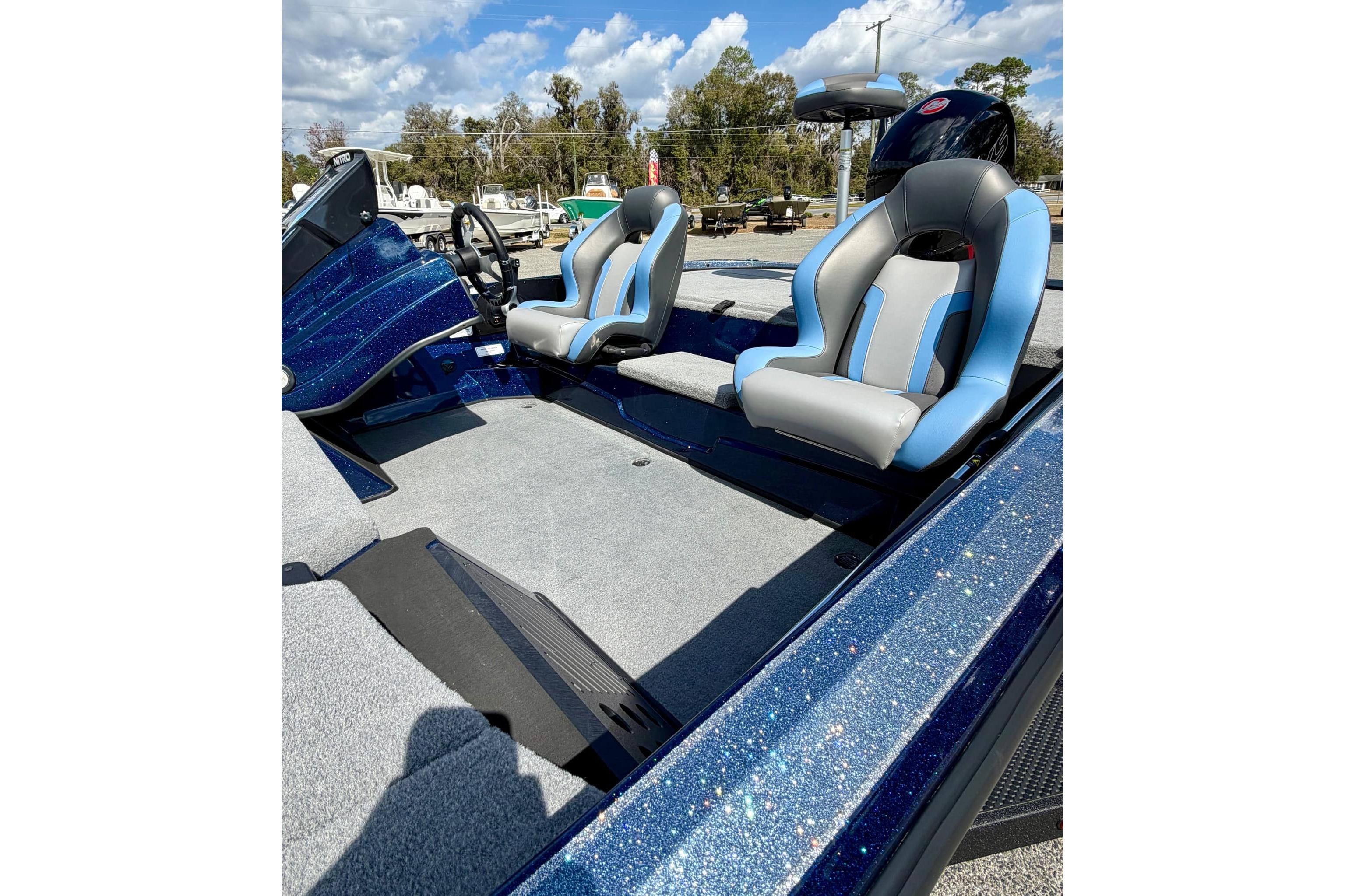 2026 Nitro Z18 boat interior with blue and gray seats under a sunny sky.