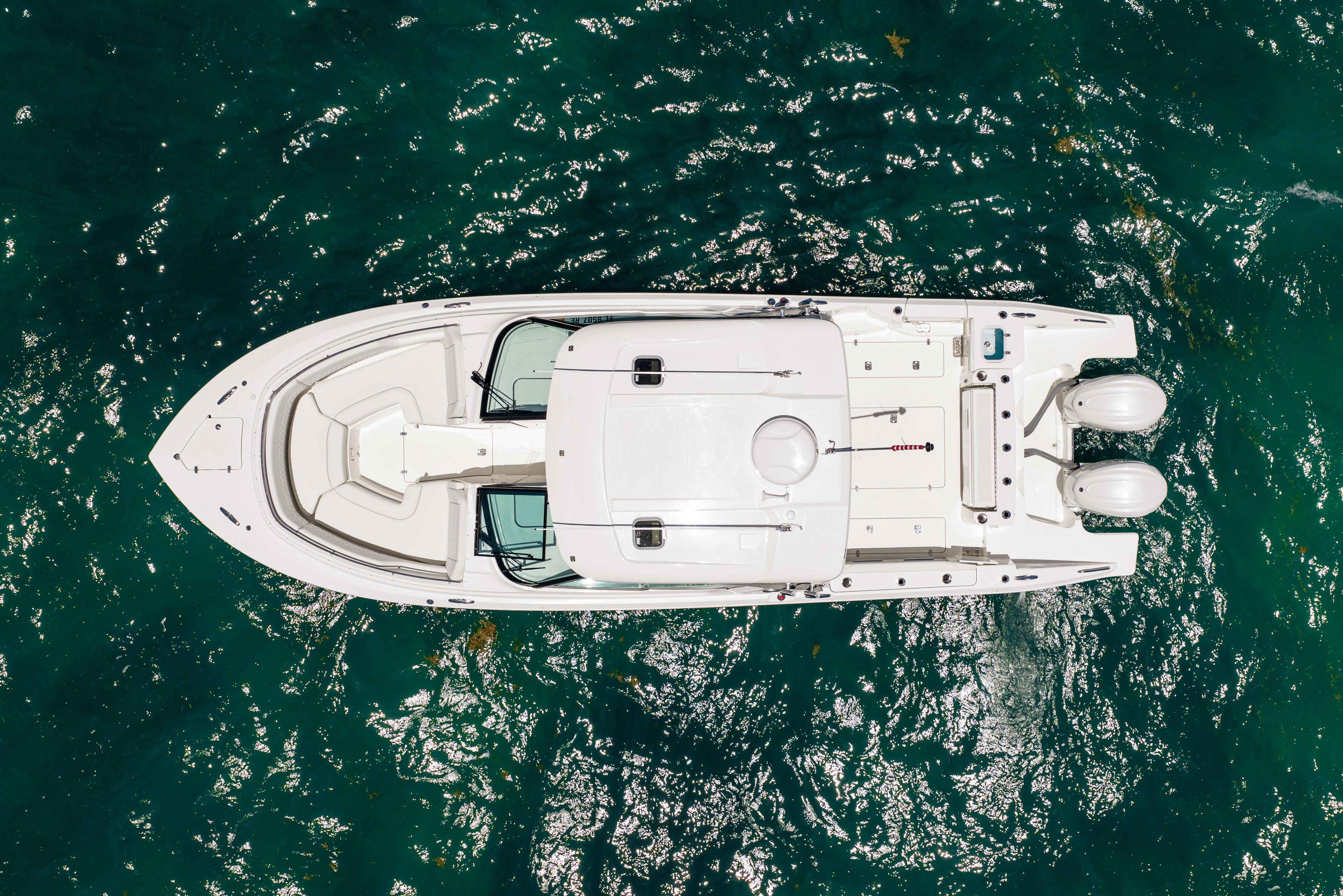 Overhead view of 2026 Pursuit DC 326 Dual Console boat on clear blue water.