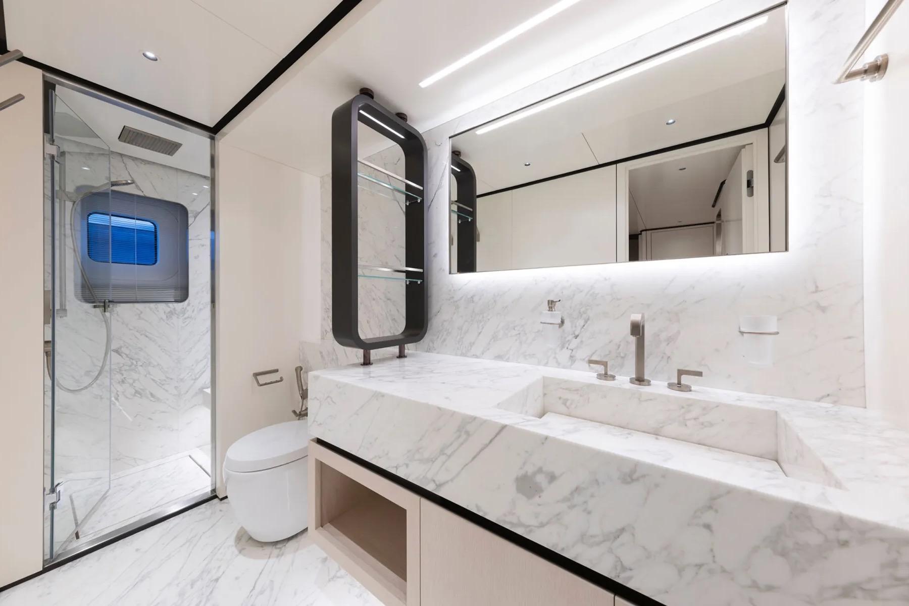 Luxurious yacht bathroom with marble finishes, modern fixtures, and glass shower in ART Shipiyard BEE EXPLORER 2025.