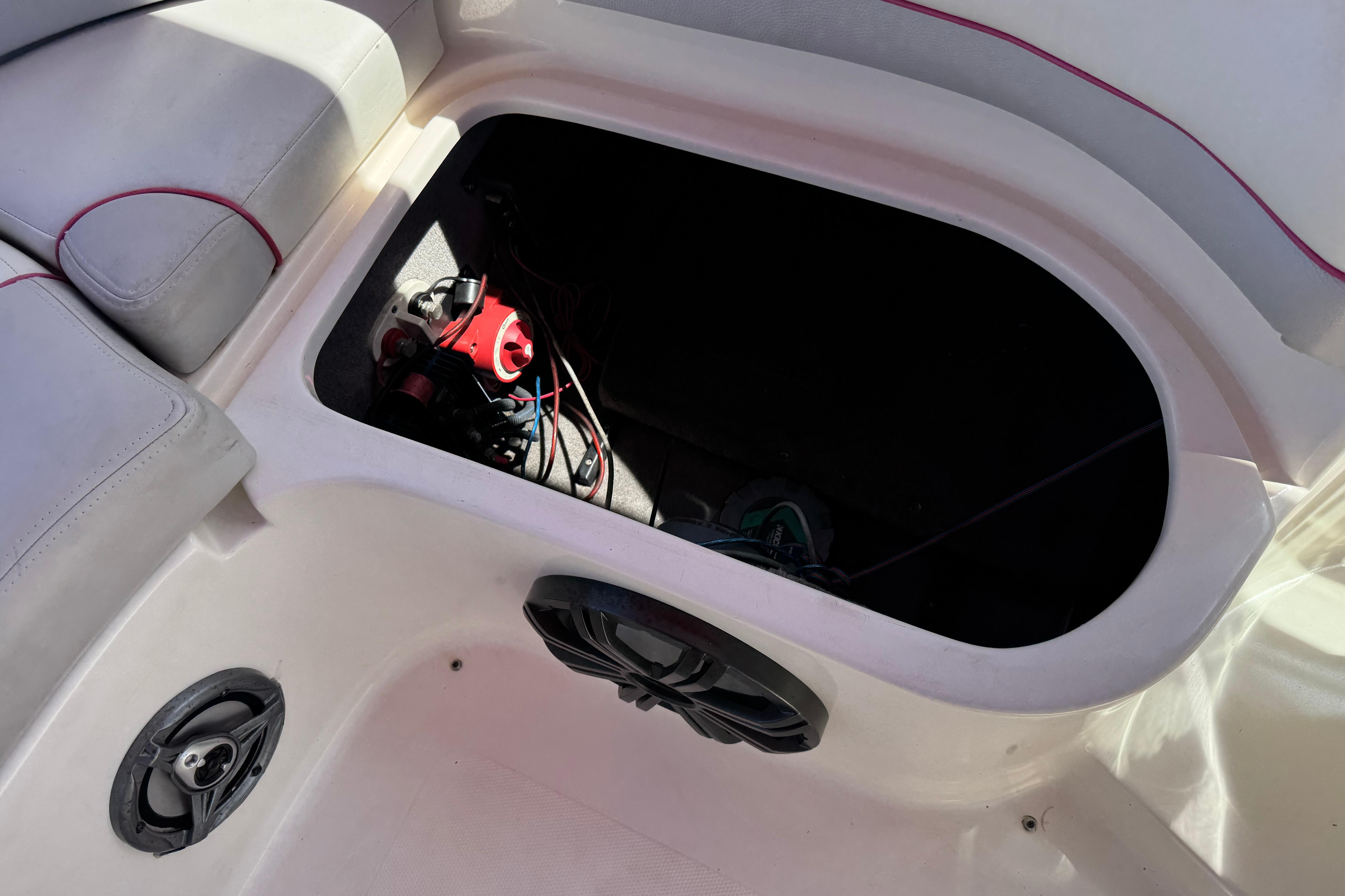 Open storage compartment in a 2010 Bryant 255 boat, revealing interior components.