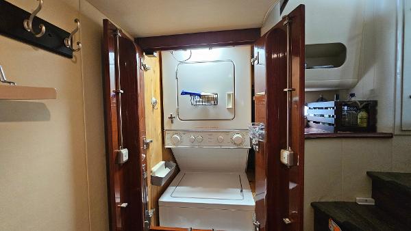 Laundry area inside 2005 Neptunus 56 Flybridge yacht with stacked washer and dryer.