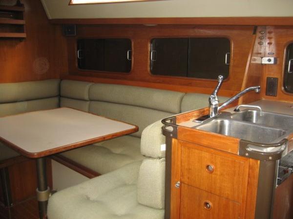 Interior of a C&C Landfall yacht with table, seating, and sink.