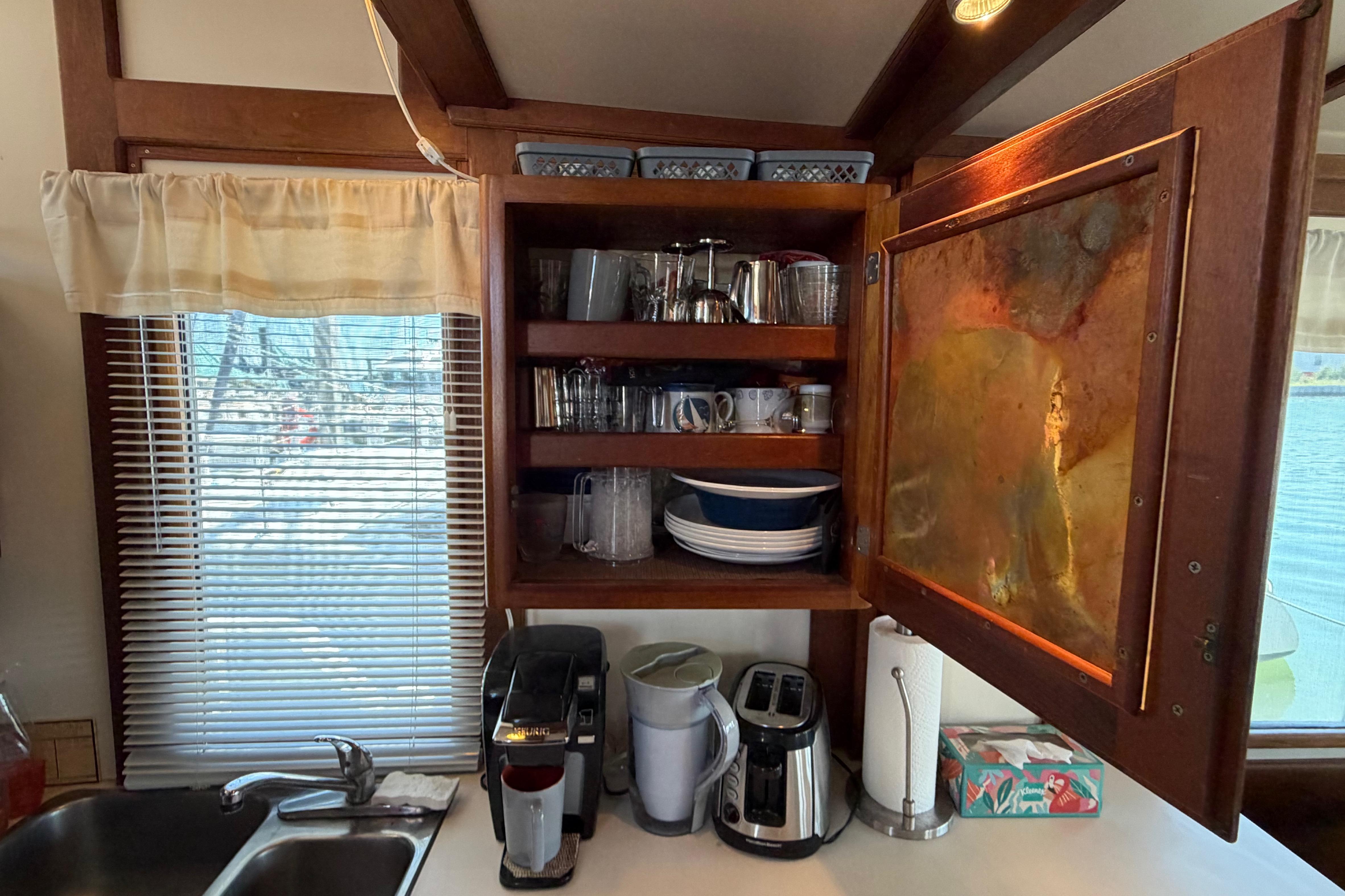 Cozy kitchen in 1985 Gozzard PILGRIM boat with open cabinet and appliances.