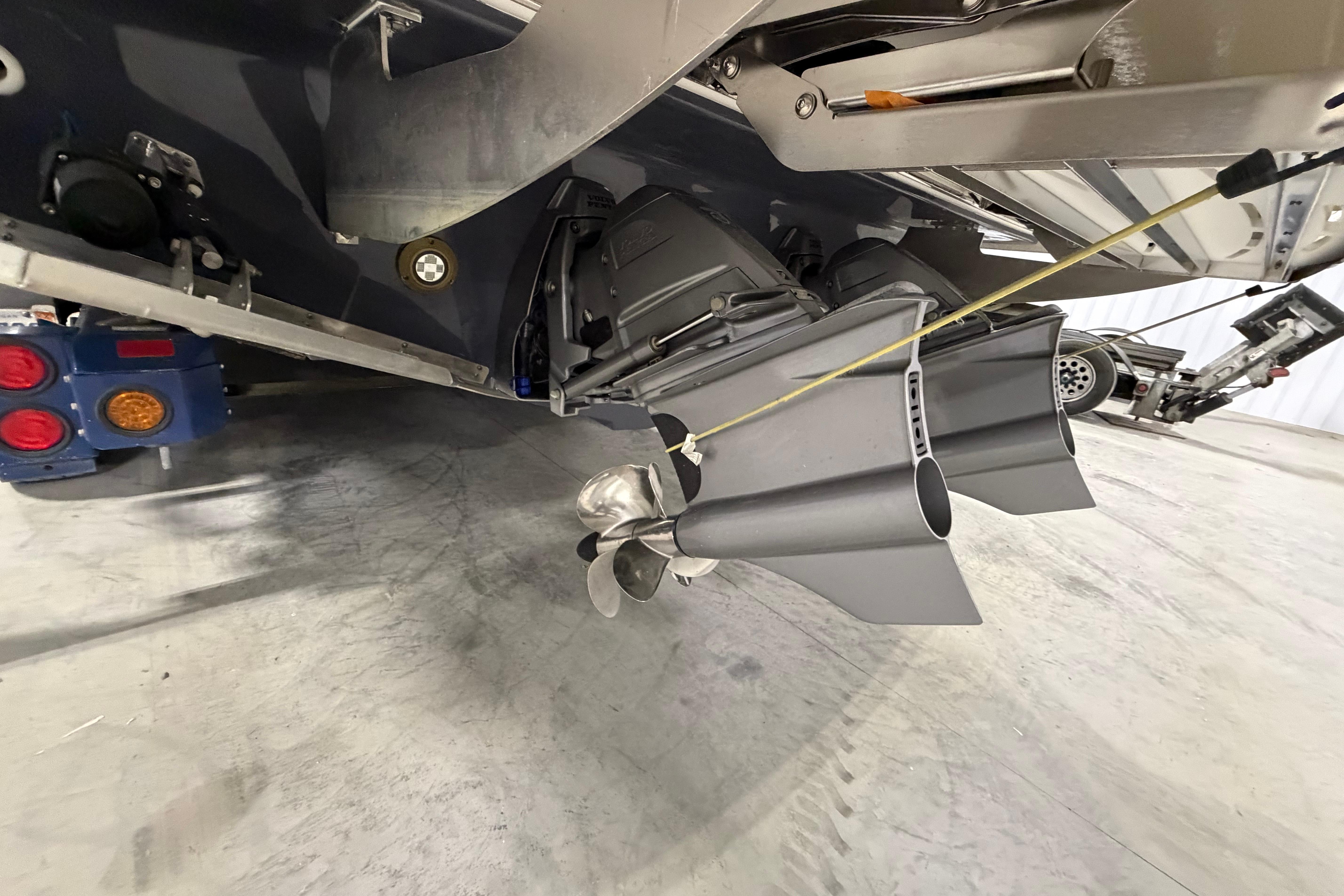 2027 Regal 38 Surf boat's propulsion system and propeller detail in a garage setting.