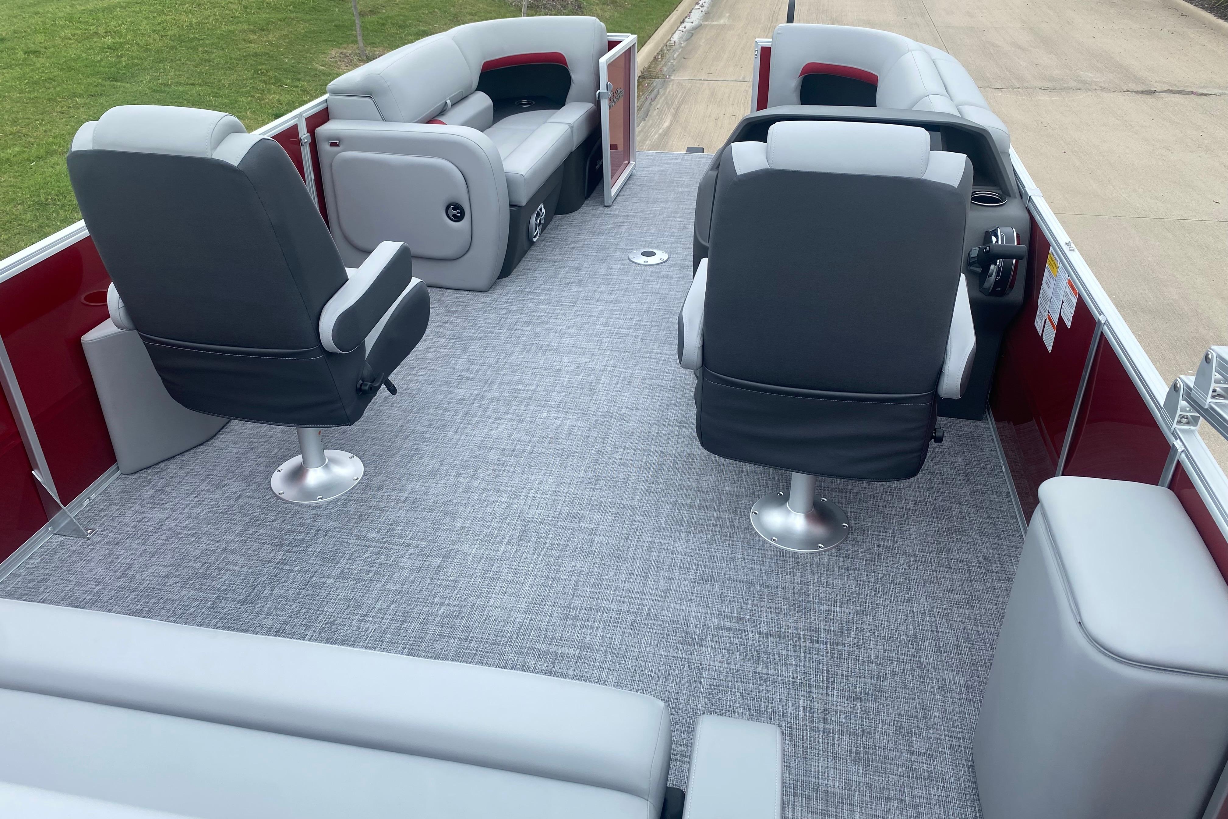 2026 Sun Tracker Party Barge 22 RF DLX interior with gray seating and carpet.