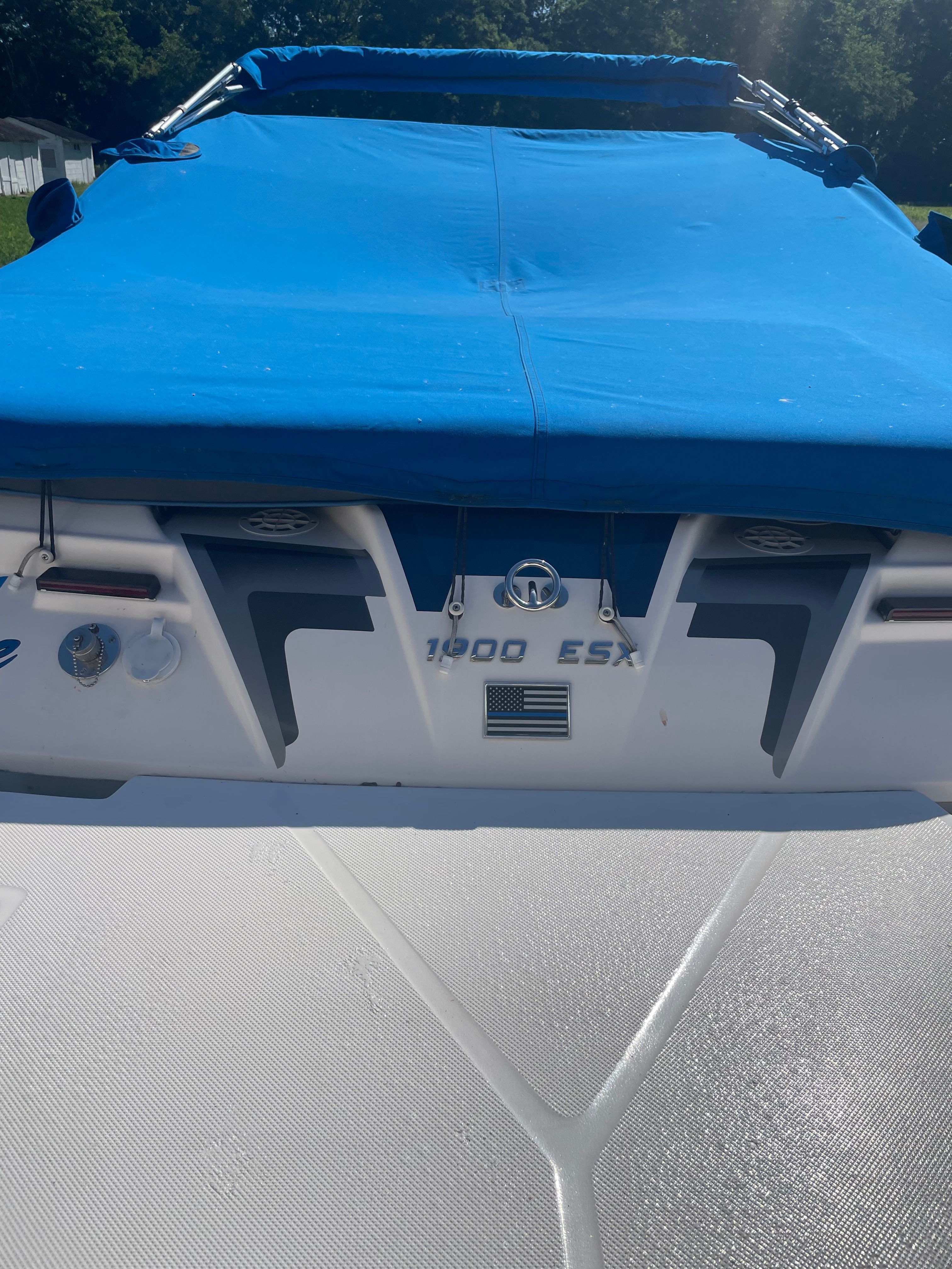 The image shows the rear of a Regal 1900 ESX Bowrider with a blue cover.
