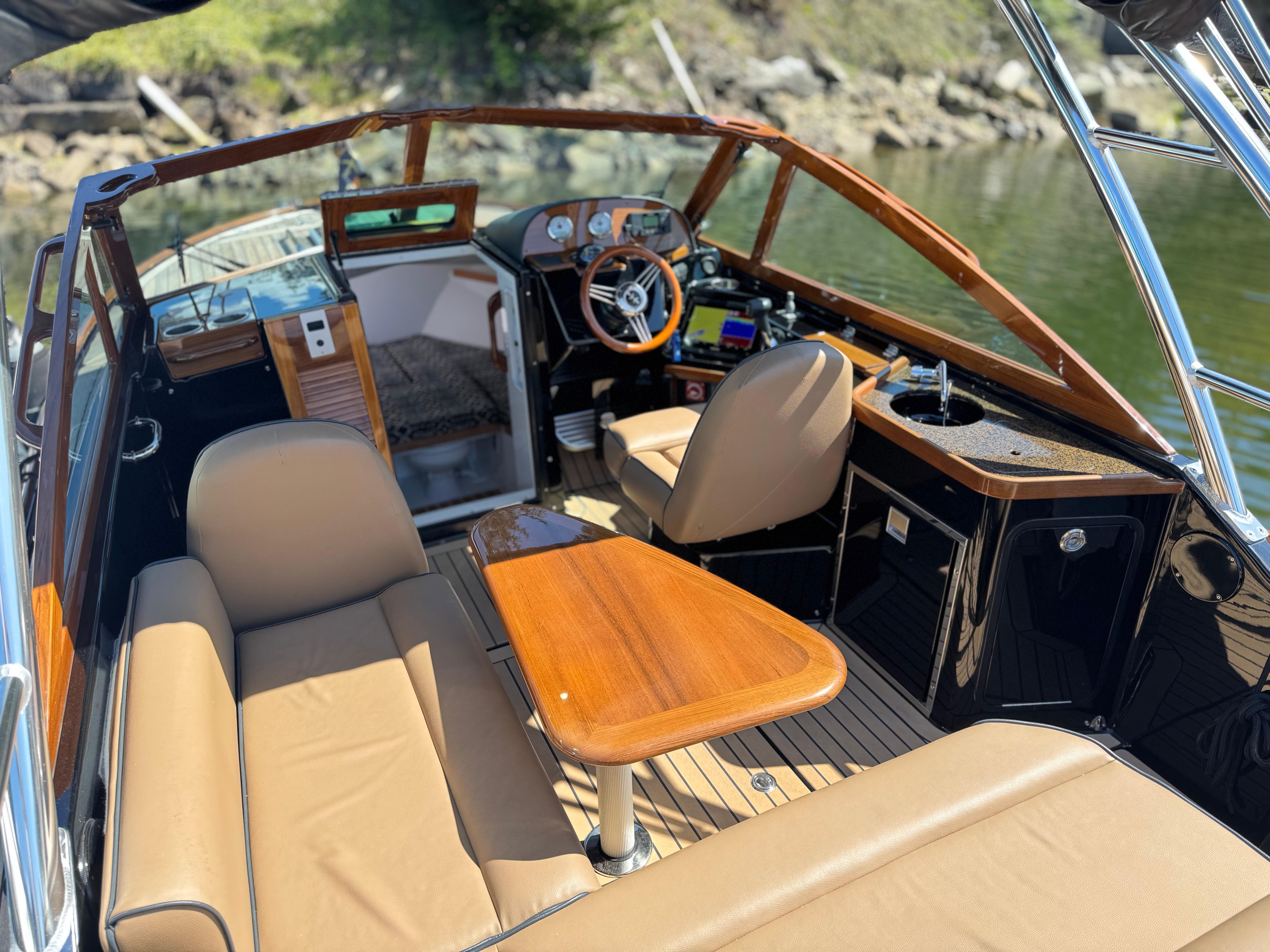 2021 Hunt Yachts Harrier 26 interior with tan seating, wooden accents, and modern dashboard.
