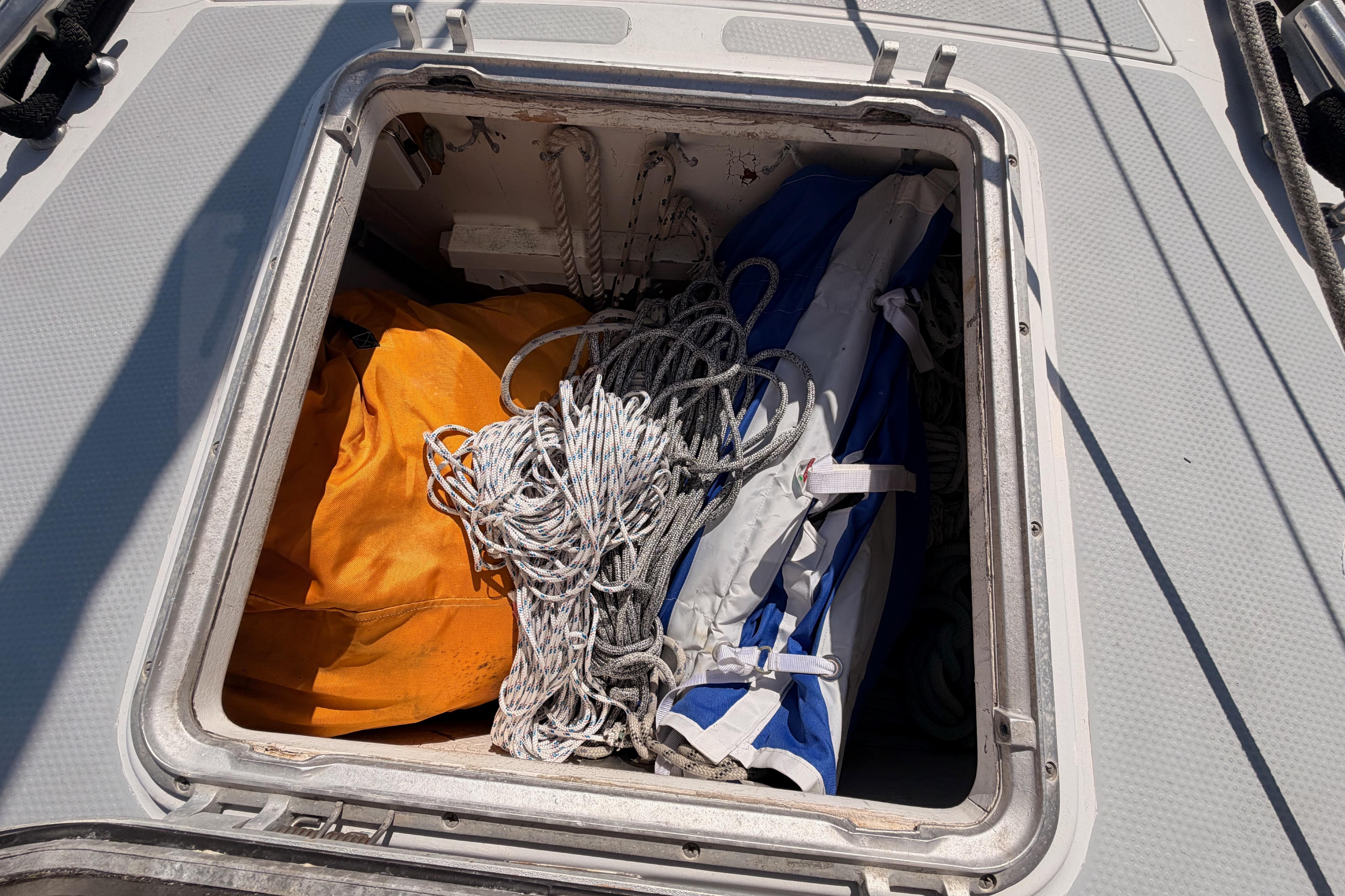 Open hatch on 1991 Hylas 51 sailboat, showing ropes and gear storage.