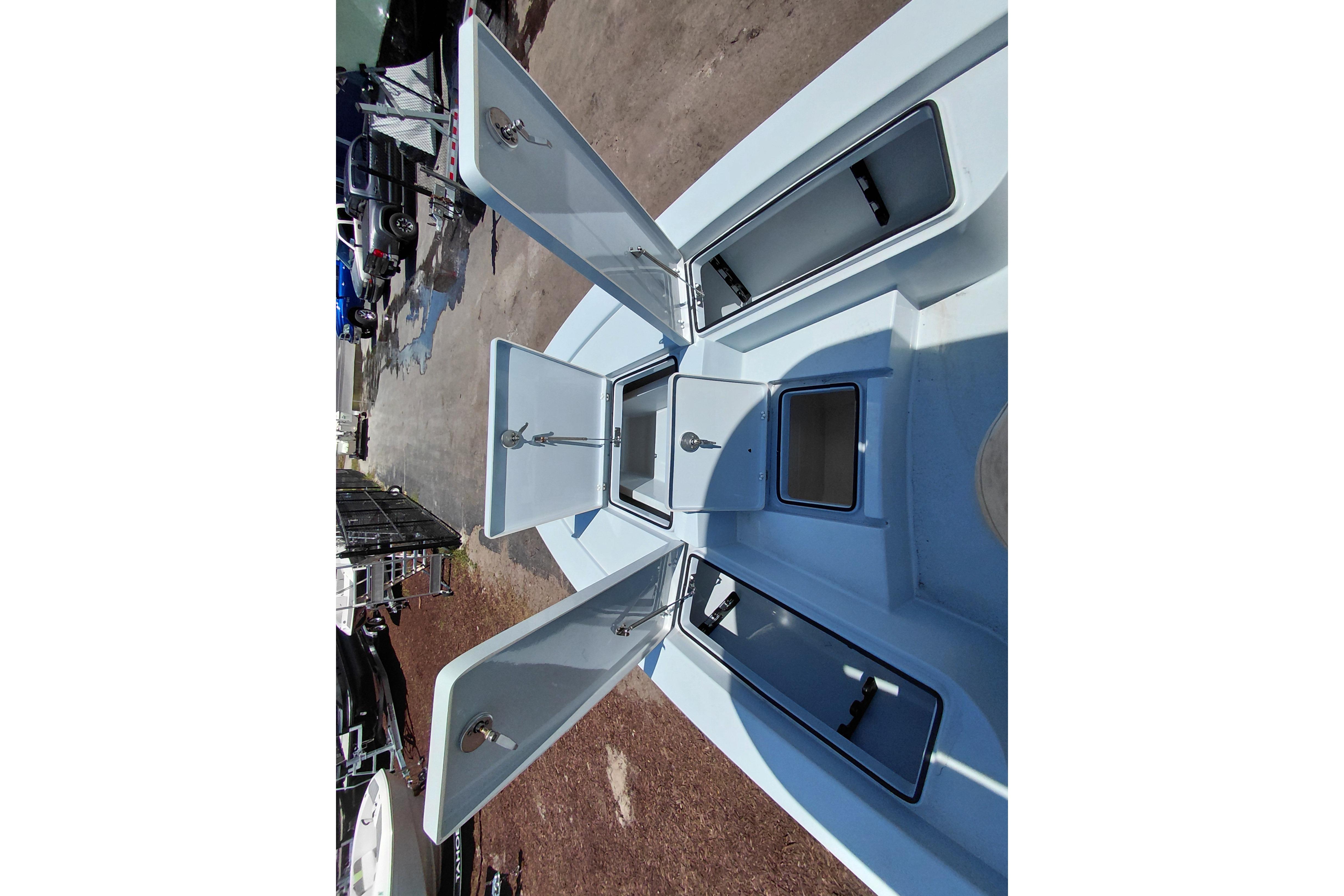 Open storage compartments on a 2022 Pathfinder 2300 HPS boat deck.