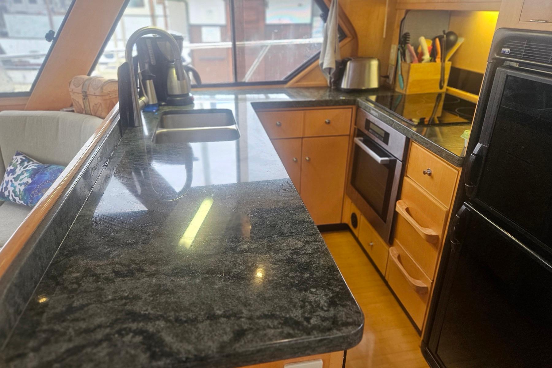 Luxurious yacht kitchen with granite countertops, modern appliances, and wooden cabinetry, Symbol 55, 1995.