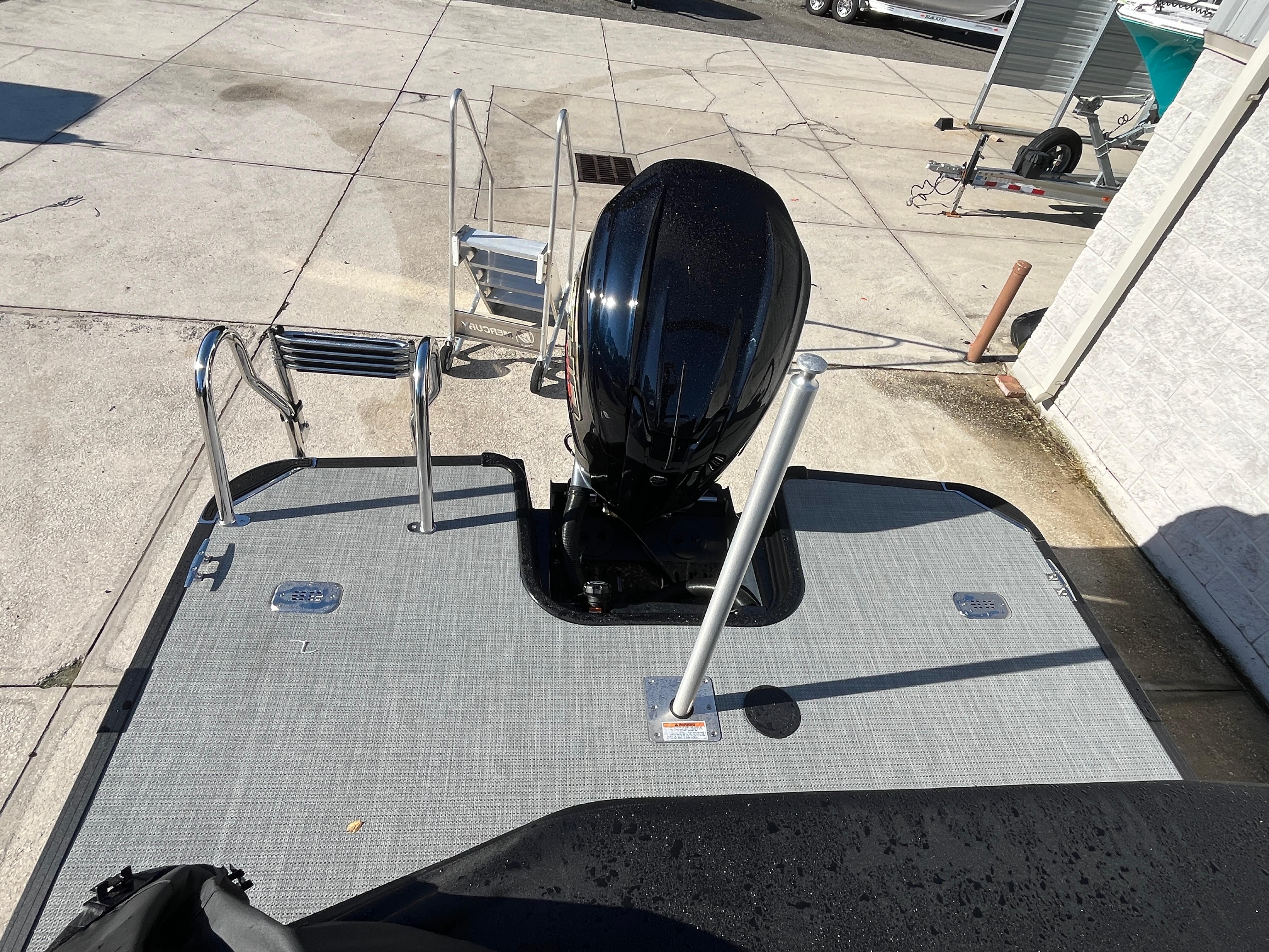 2025 Starcraft EXS-3 boat with outboard motor and swim platform, parked on concrete.