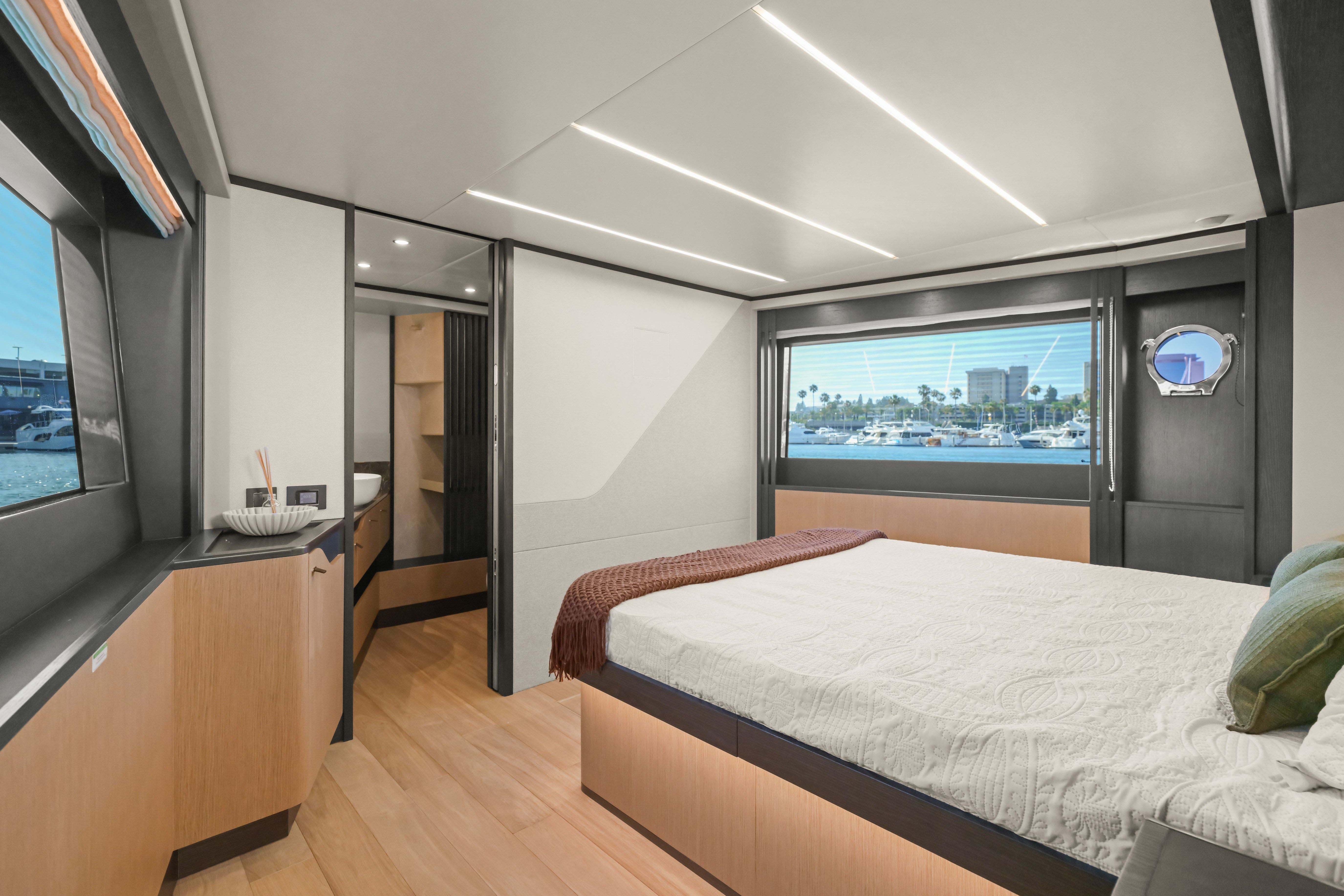 Luxurious interior of 2026 Absolute 52 Fly yacht with modern bedroom and scenic window view.