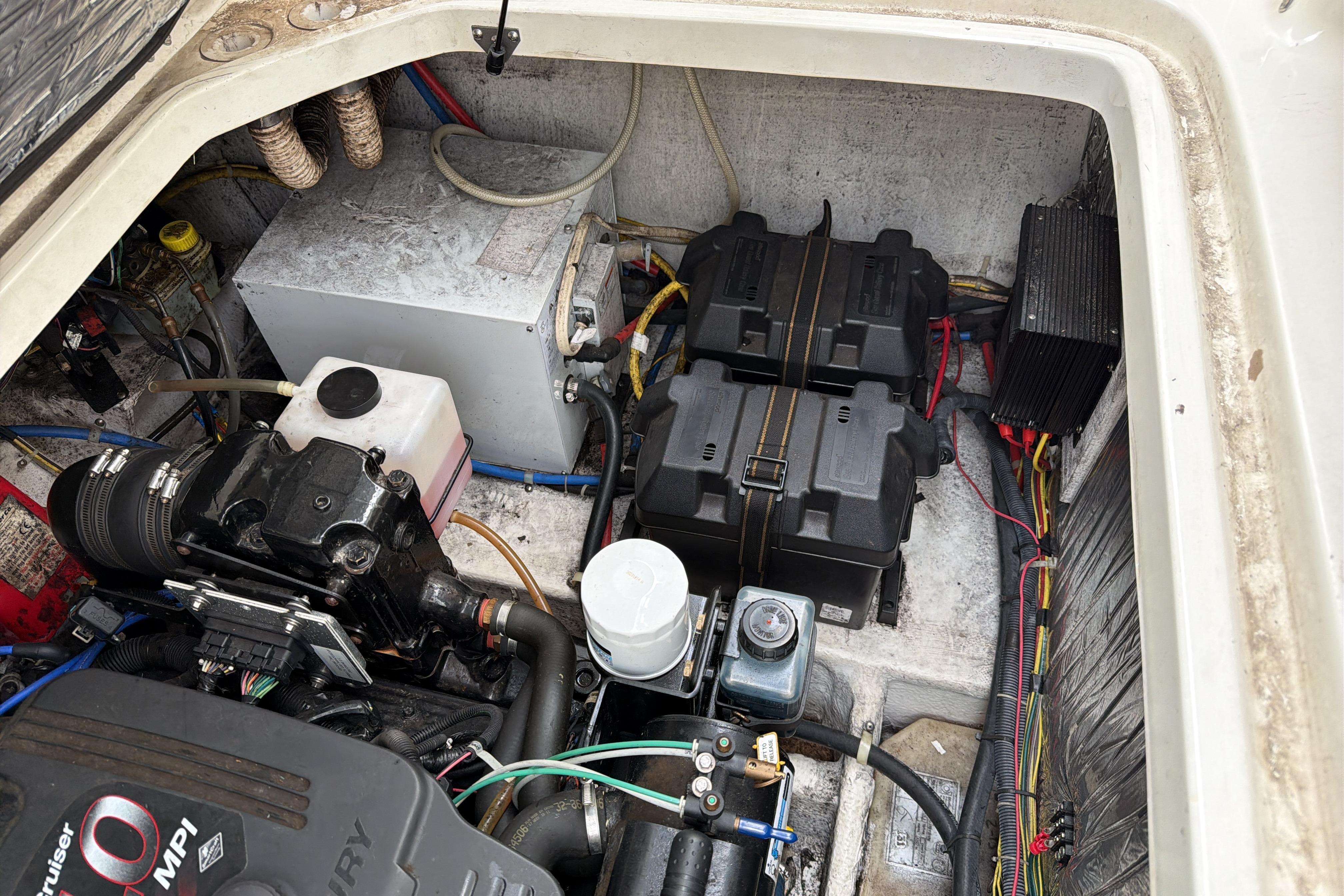 Engine compartment of a 2007 Bayliner 245 boat, showing batteries and wiring.