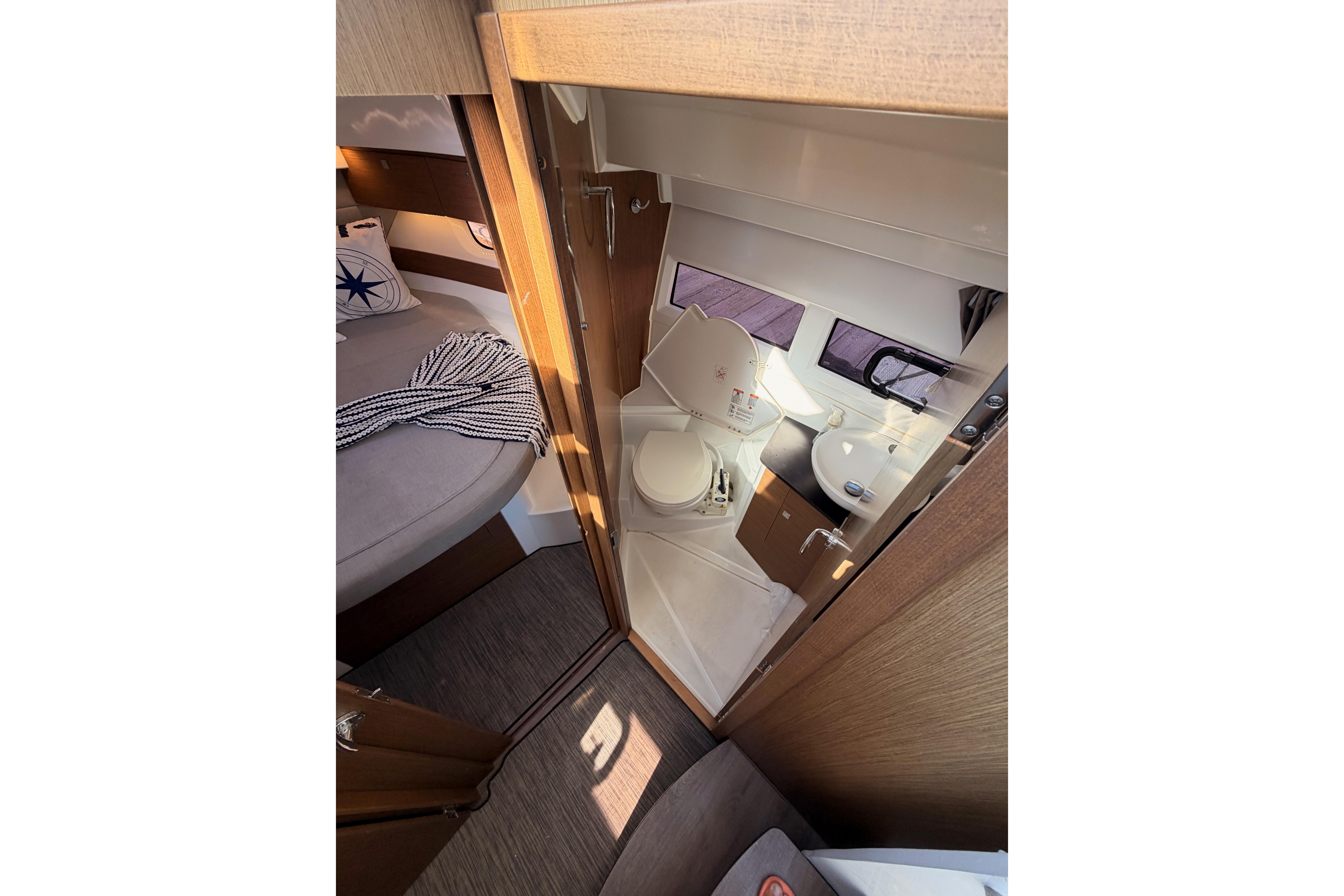 2020 Jeanneau NC 895 interior showing compact bathroom and cozy sleeping area.