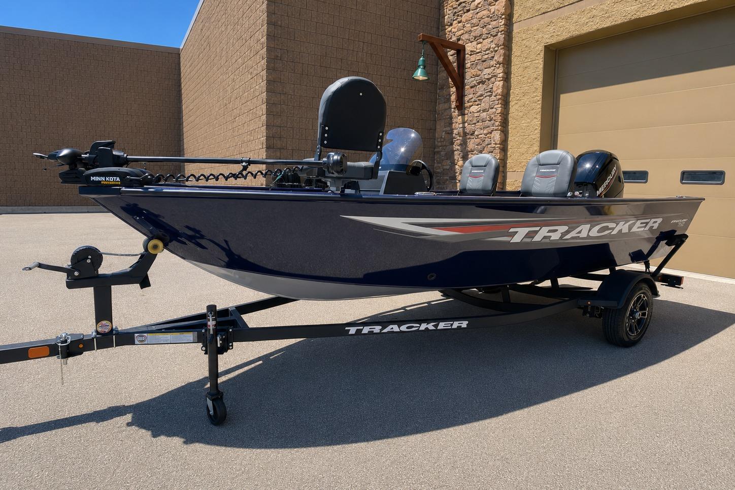 2026 Tracker Pro Guide V-16 SC fishing boat on trailer, parked outdoors.