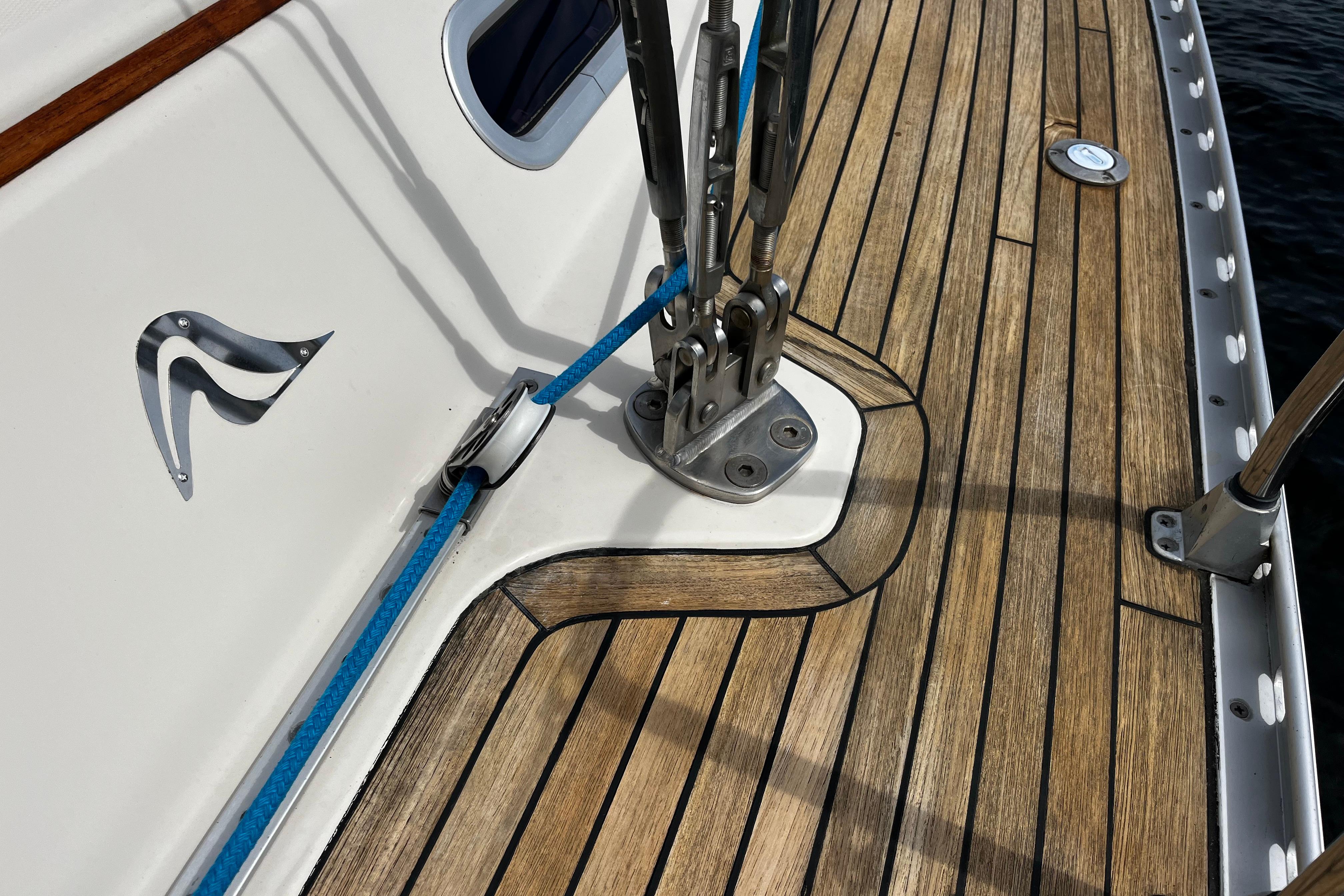 Teak deck of 2004 Hanse 411 sailboat with blue rope and metal fittings.