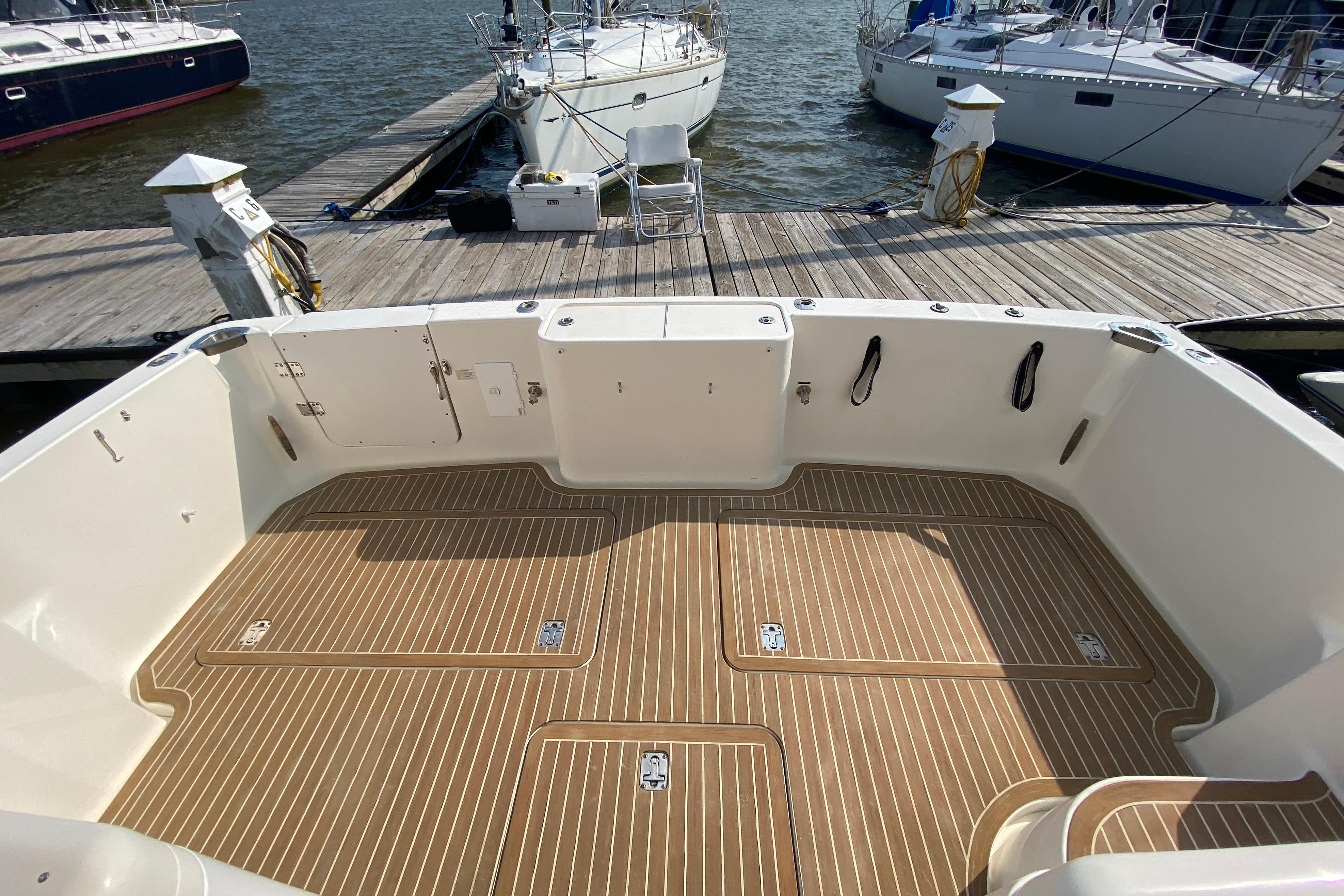 2005 Silverton 38 Convertible boat deck with wood finish, docked at marina.