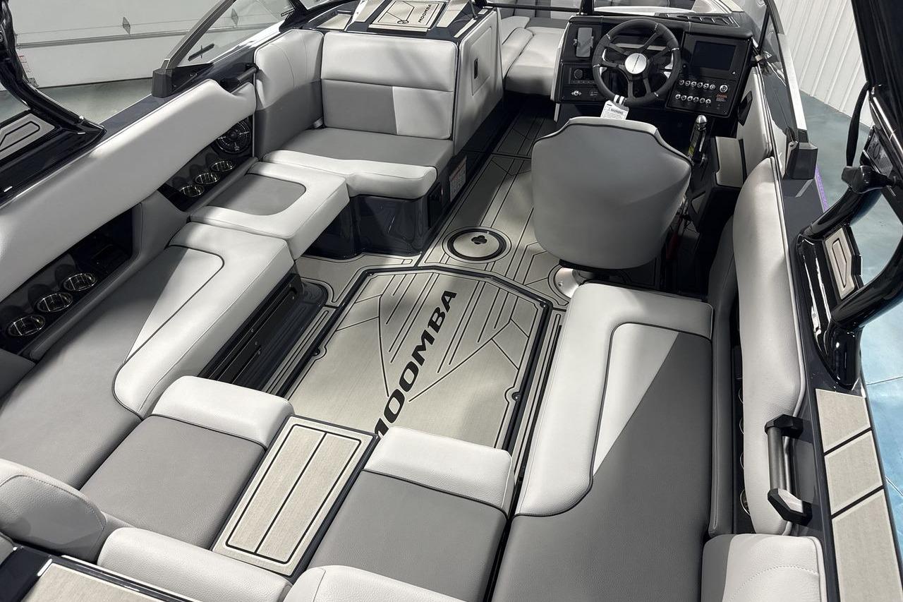 Interior of a Moomba Craz boat with gray upholstery and a modern dashboard.