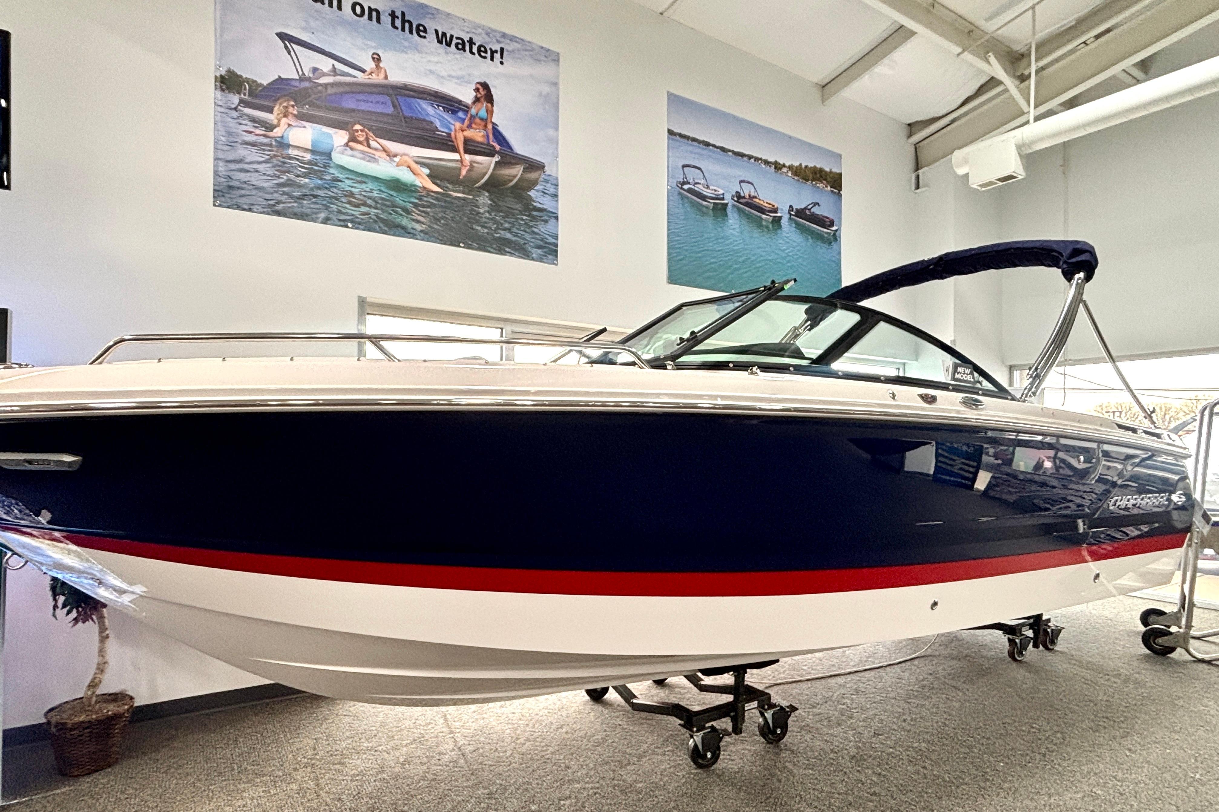 2026 Chaparral SSX 4 boat displayed indoors with promotional posters above.