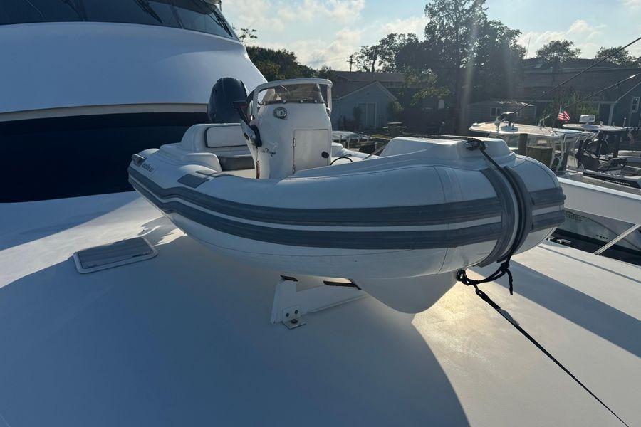 2002 Viking 61 Enclosed Bridge yacht with a small inflatable boat on deck.