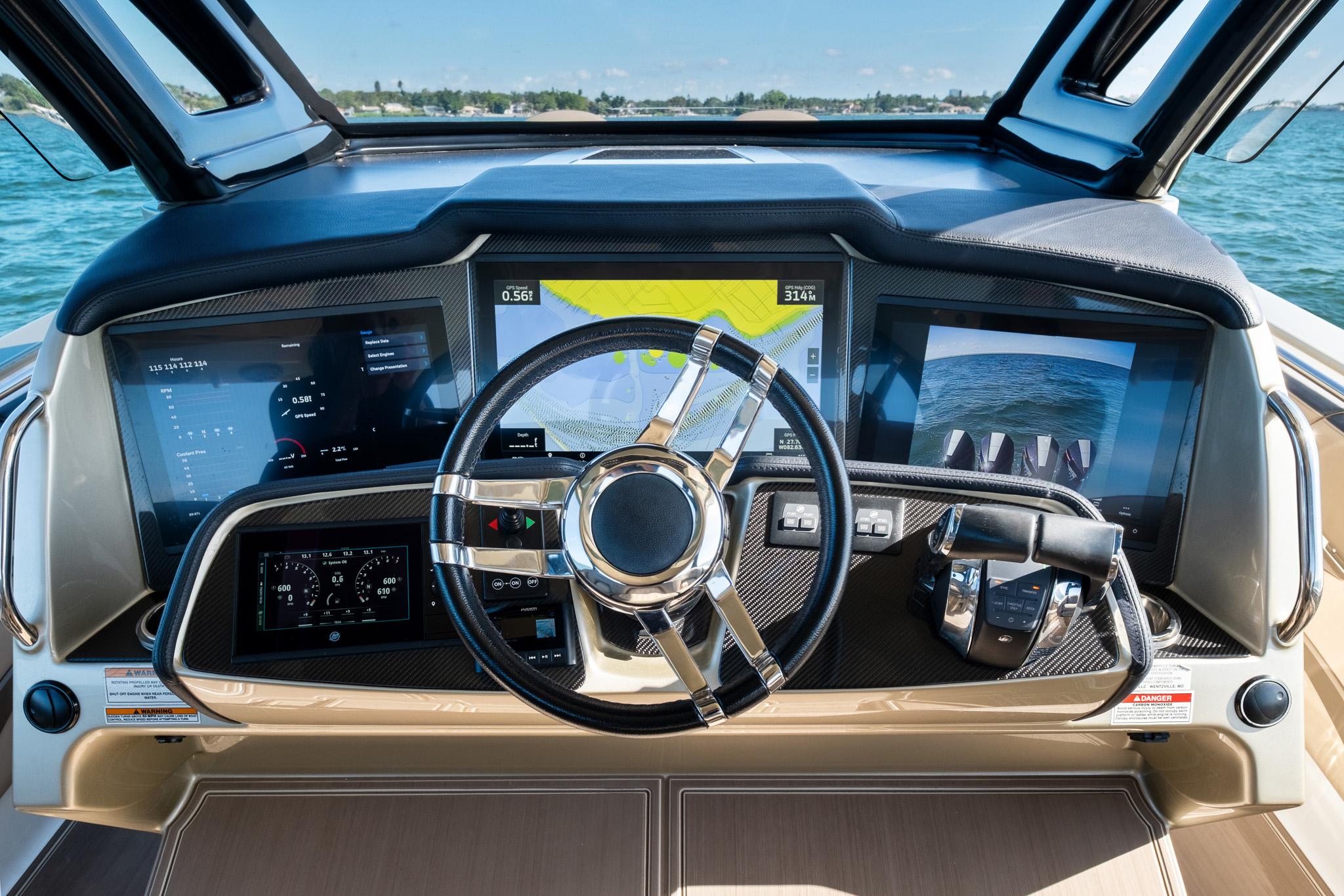 Cockpit of 2021 MTI V42 boat with advanced navigation screens and steering wheel.