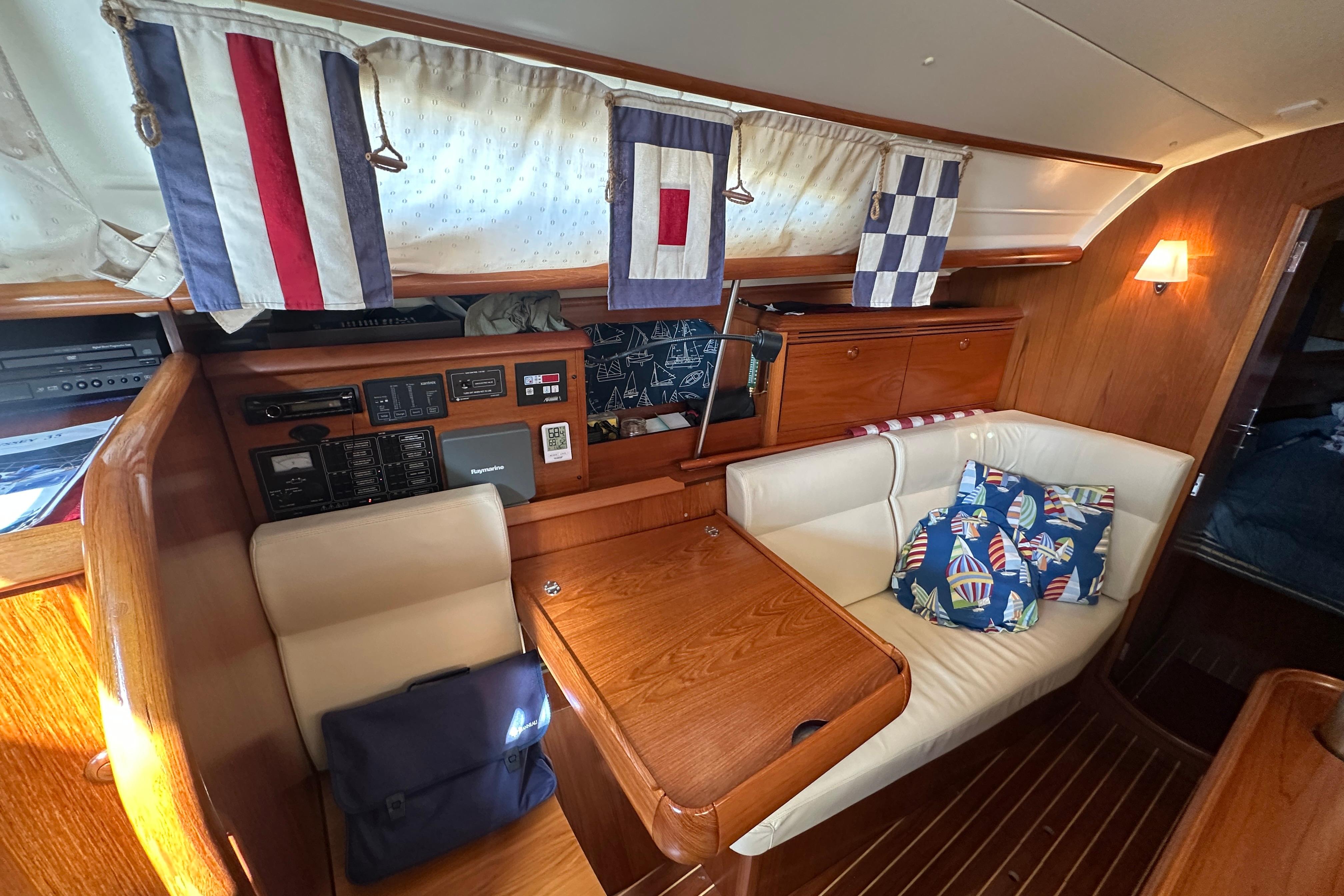 Cozy interior of 2004 Jeanneau Sun Odyssey 35 sailboat with nautical decor and seating area.