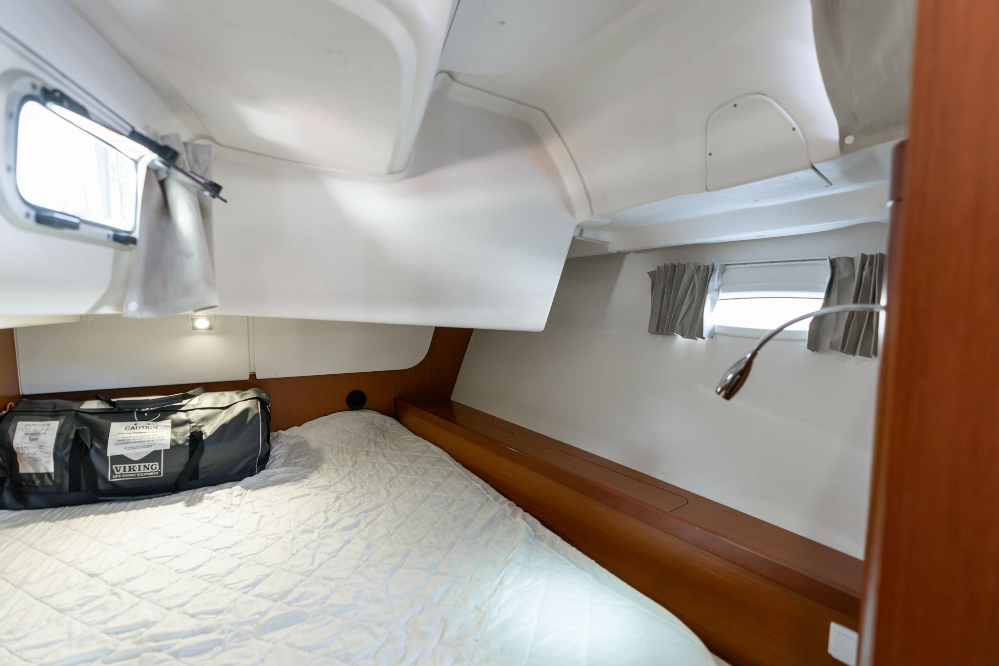 Cozy cabin interior of 2013 Beneteau Oceanis 50 sailboat with bed and porthole.