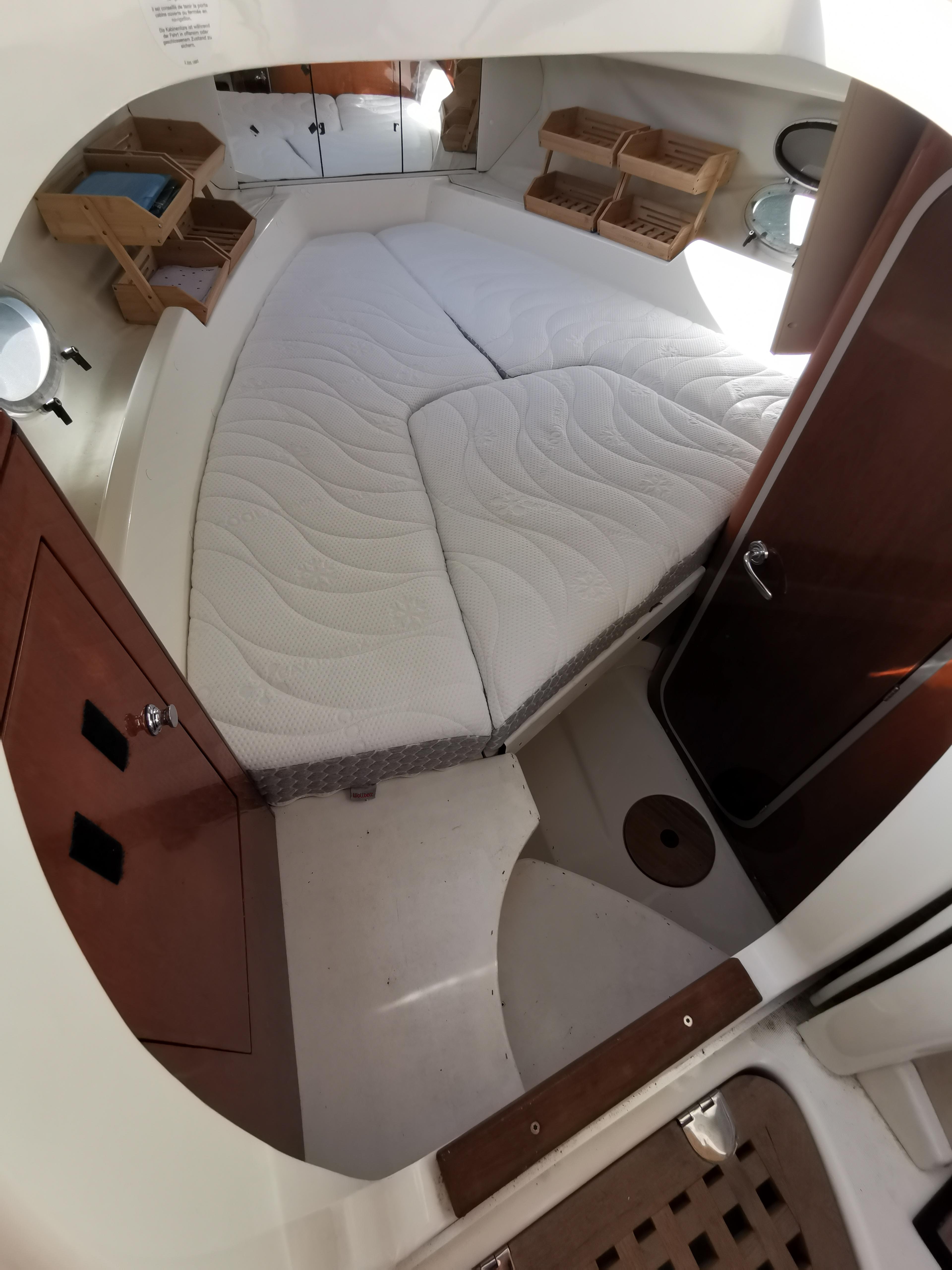 Interior cabin of 1999 Cranchi CSL 28 boat with bed and wooden storage.