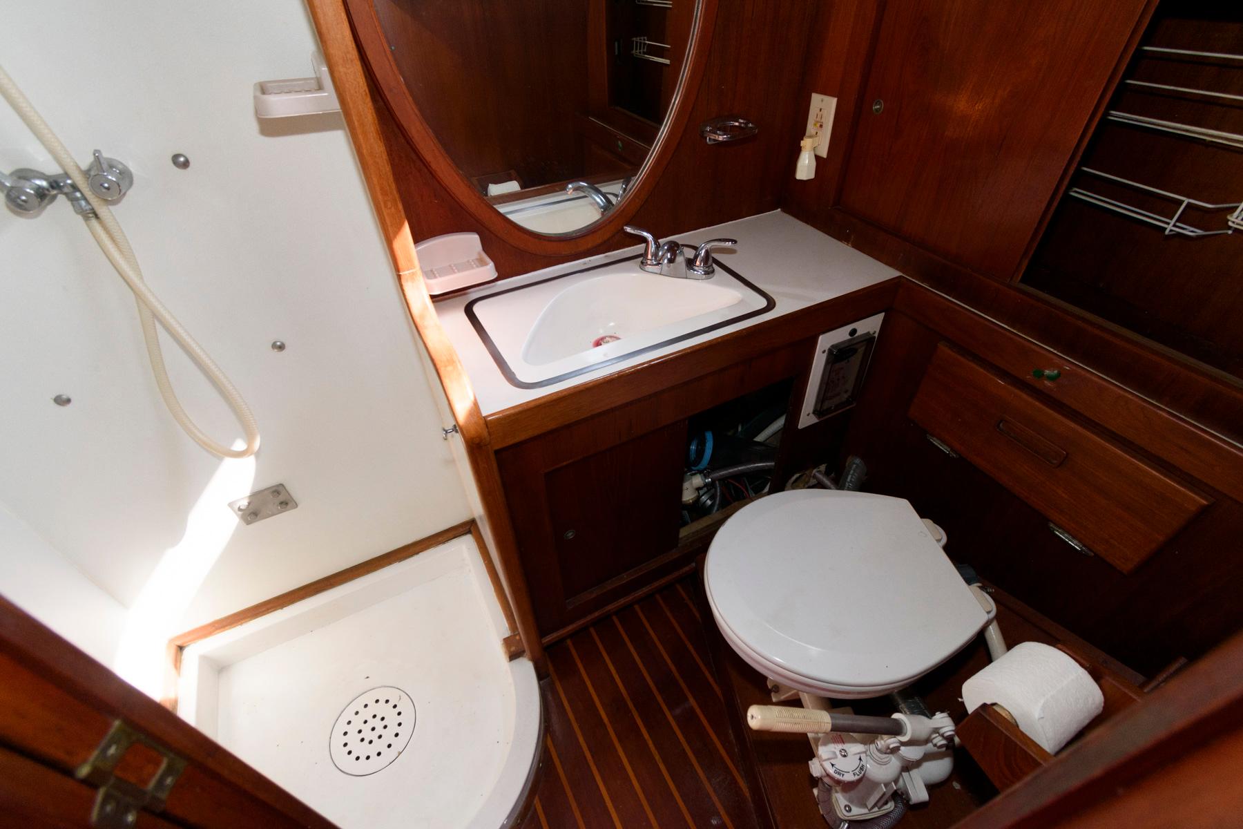 1977 Gulfstar 50 Center Cockpit bathroom with shower, sink, and toilet.