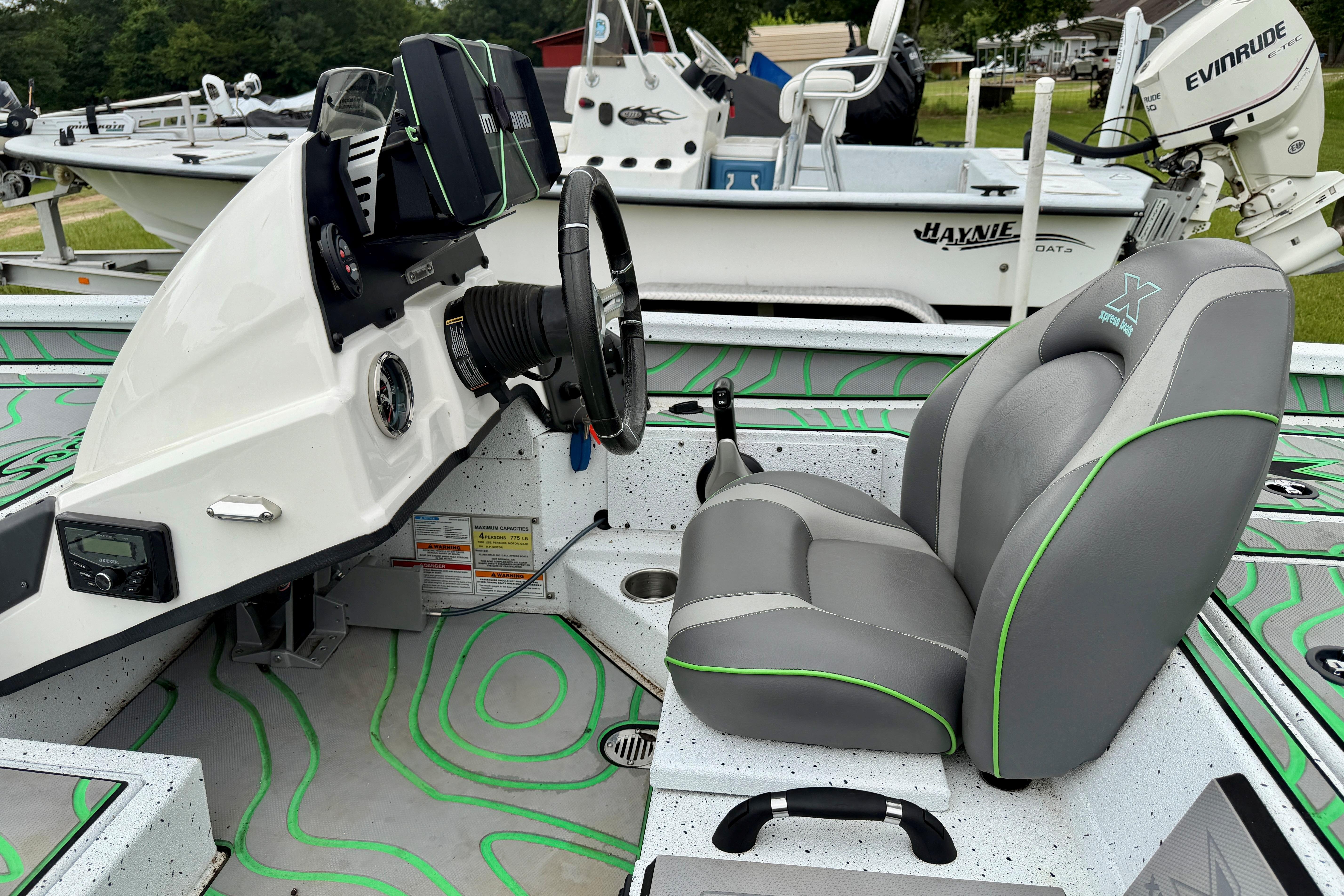 2022 Xpress X21 Pro boat interior with steering wheel and cushioned seat.